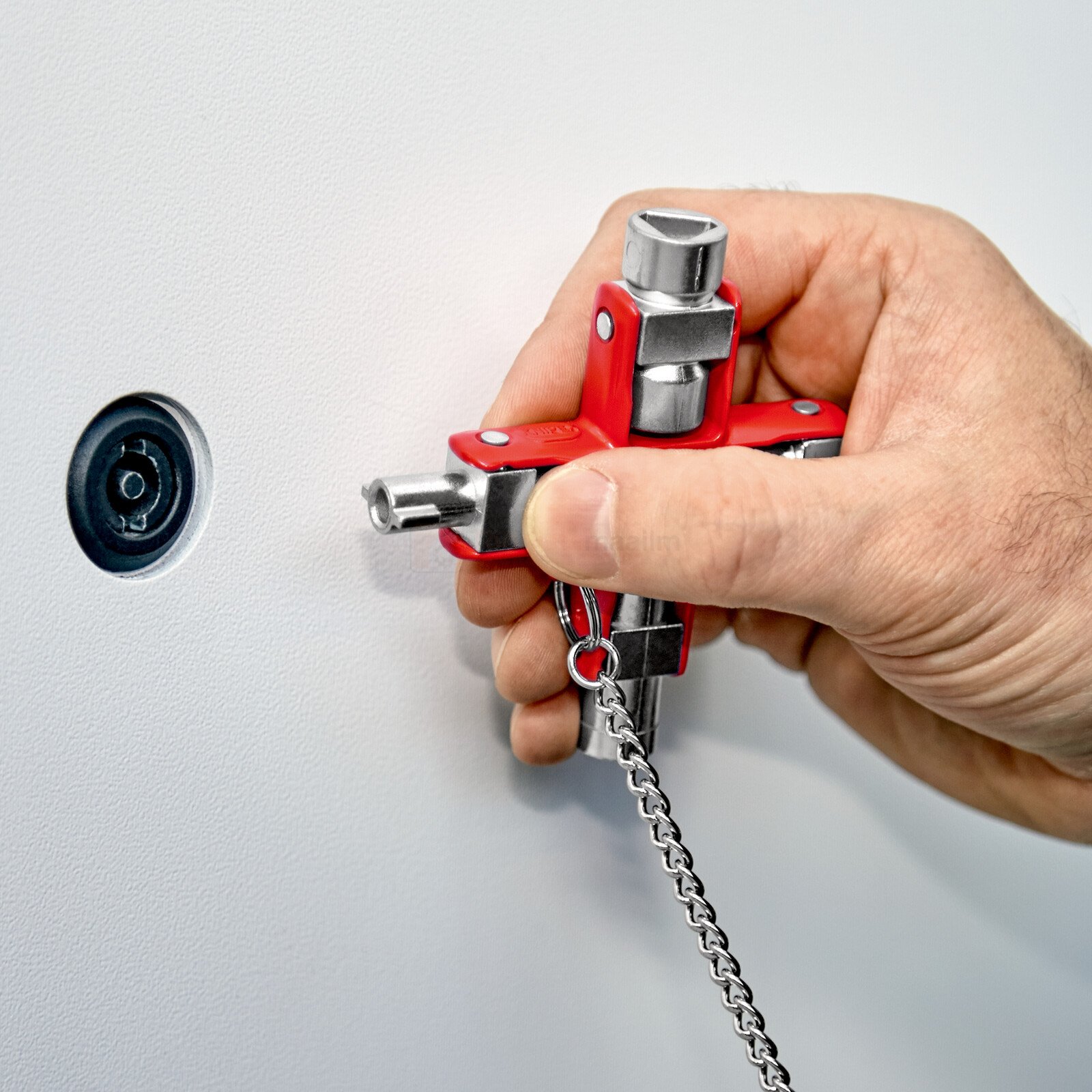 Pildil on käsi, mis hoiab Knipex universaalset võtit, mida kasutatakse standardsete kappide ja väljalülitussüsteemide...