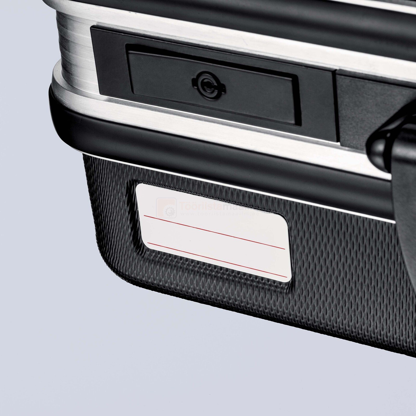 Pildil on näha Knipex tööriistakohver „Basic“ nurk, millel on mustad detailid, hõbedane serv, nimesilt ja lukustusmehhanism.