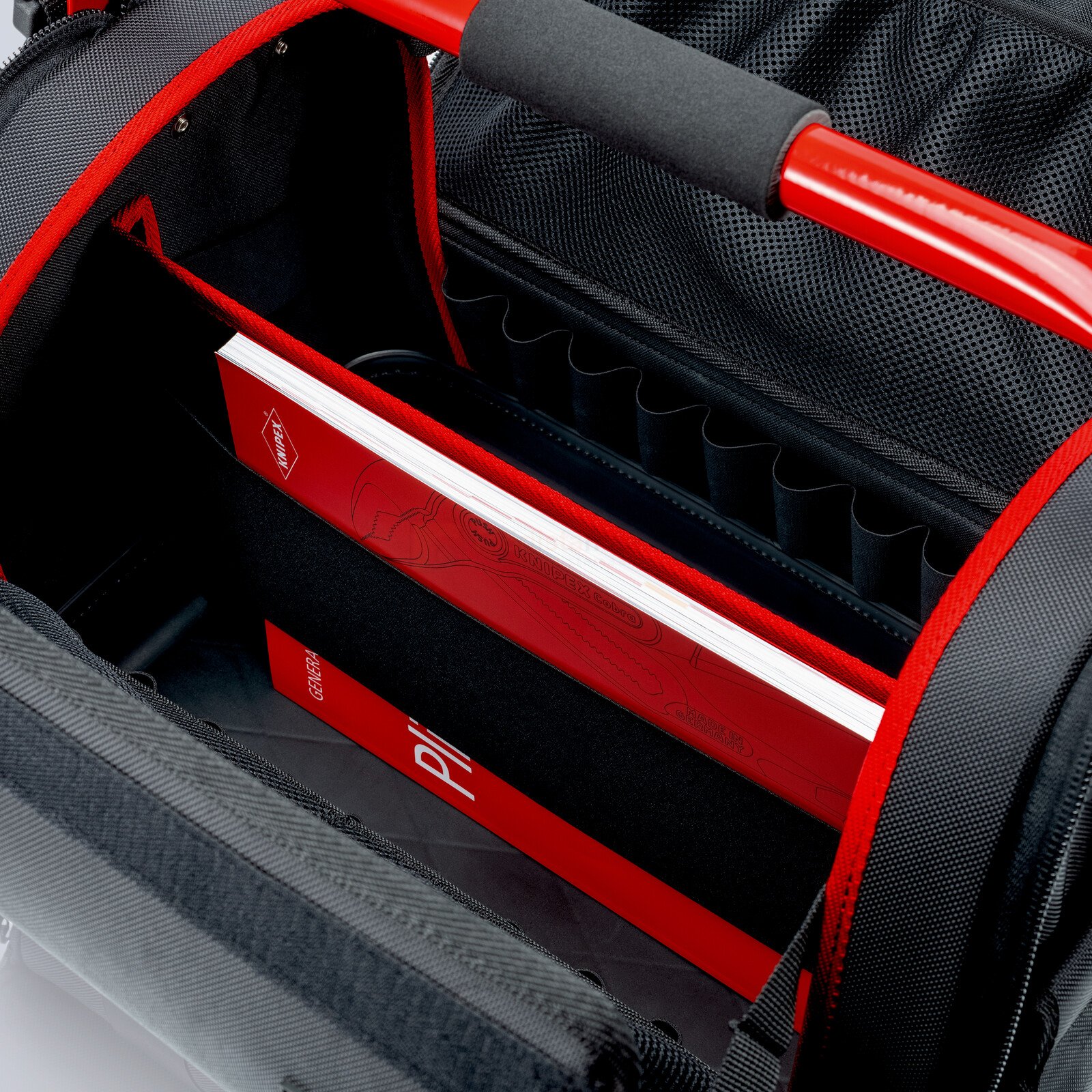 Pildil on Knipex "LightPack" tööriistakott, mille sisemuses on näha raamatuid ja tööriistade jaoks mõeldud sahtleid.