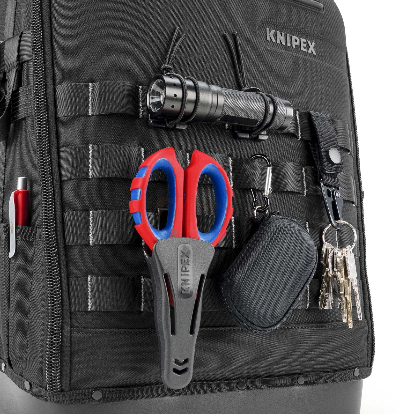 Pildil on must KNIPEX Modular X18 tühi tööriistakott, mille külge on kinnitatud taskulamp, käärid, võtmed ja muud tarvikud.