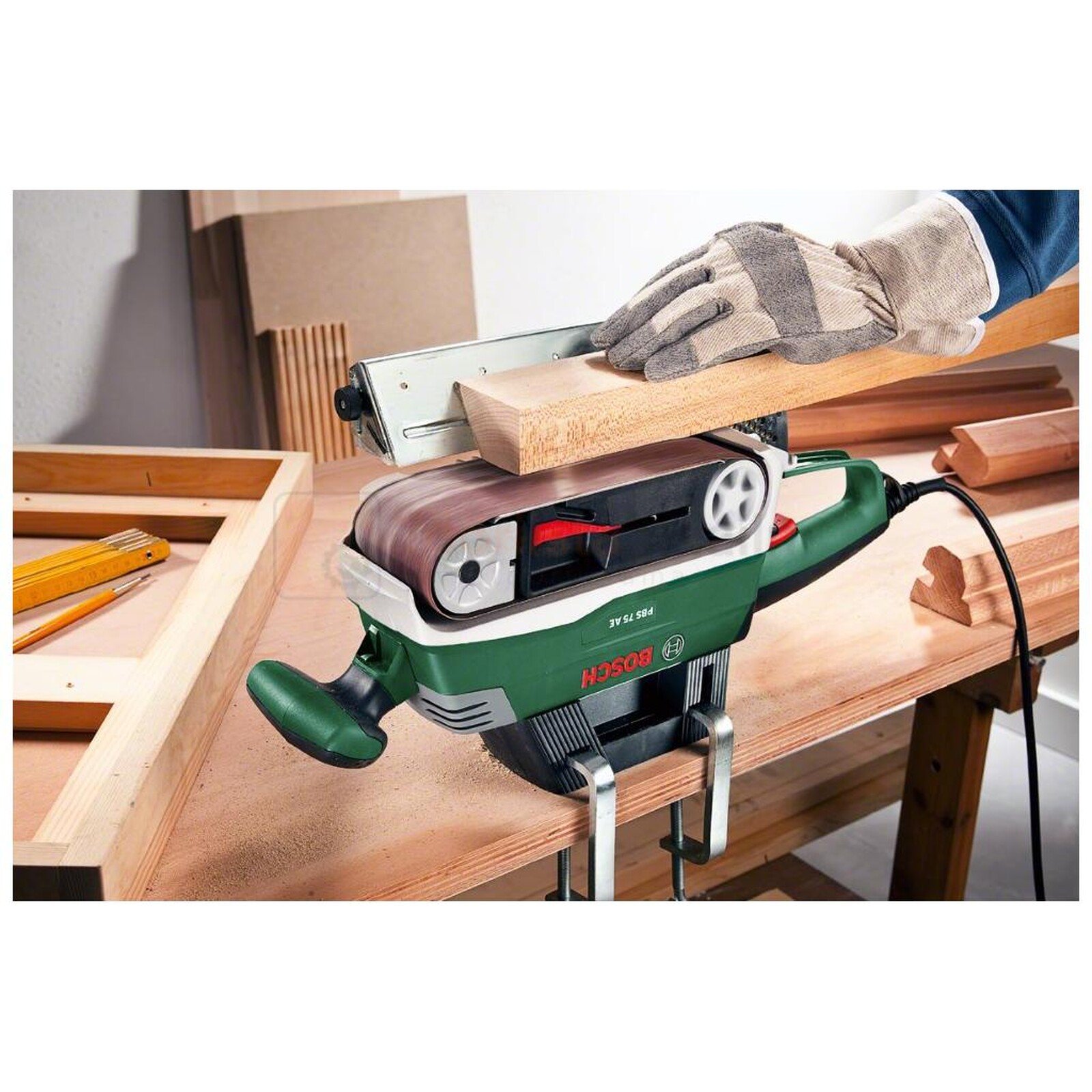 Pildil on Bosch lintlihvija PBS 75 AE, mida kasutatakse puidu lihvimiseks, näidates tööriista kasutamist ja kinnitamist...