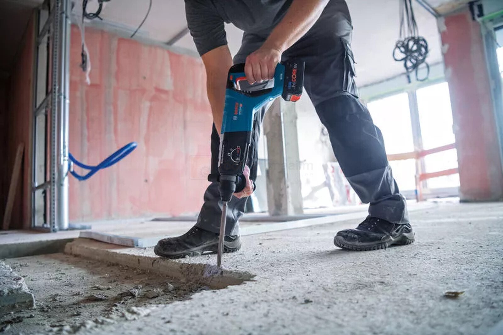 Pildil on ehitustööline, kes kasutab Bosch akupuurvasarat GBH 18V-28 D betooni lõhkumiseks.