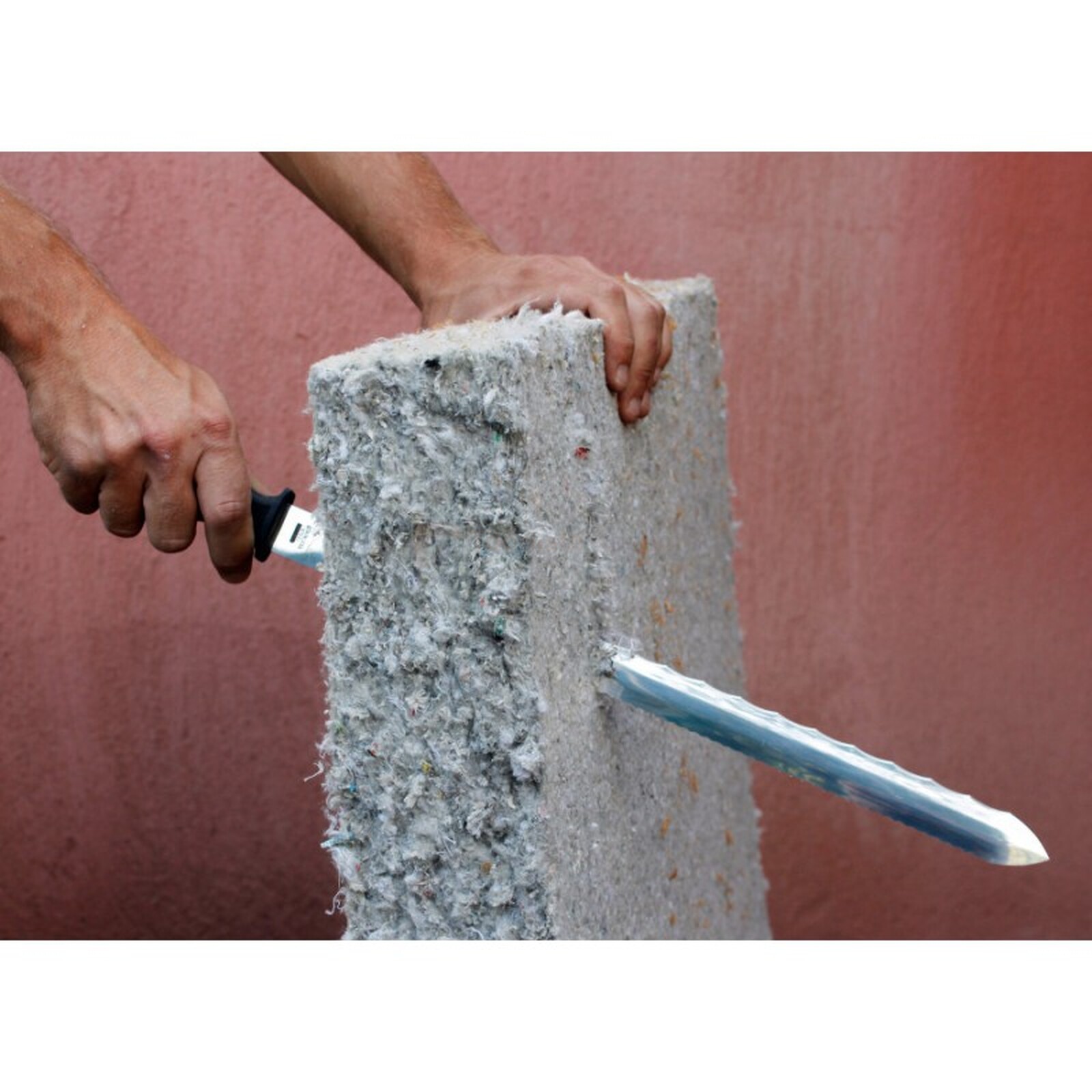 Pildil on näha, kuidas mees lõikab Edma villanuga 300 mm abil läbi isolatsioonimaterjali.