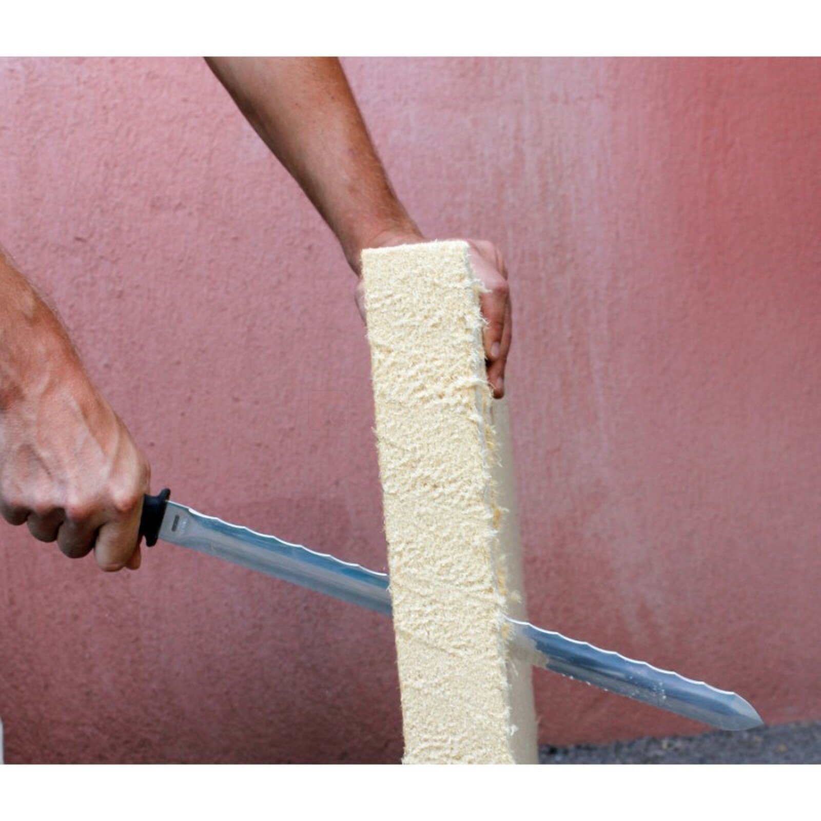 Pildil on näha, kuidas inimene lõikab Edma villanuga 300 mm abil isolatsioonimaterjali.