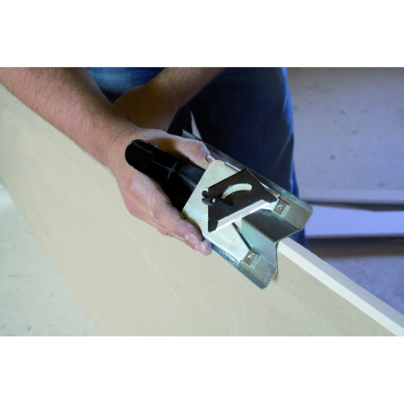 Pildil on näha, kuidas mees kasutab Edma kipsplaadi serva faasimise höövlit Rap Plac, et faasida kipsplaadi serva.