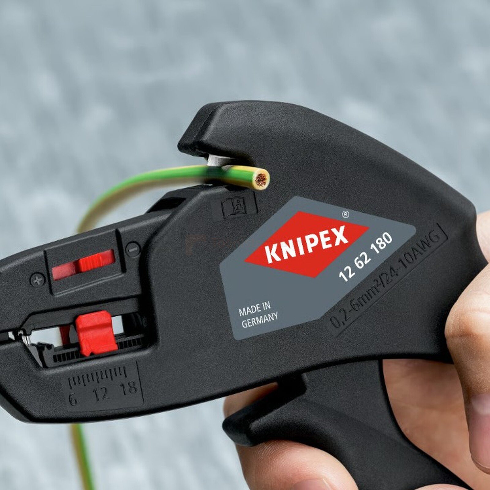 Pildil on näha, kuidas Knipex automaatsete kaablikoorimistangidega kooritakse rohelist kaablit.