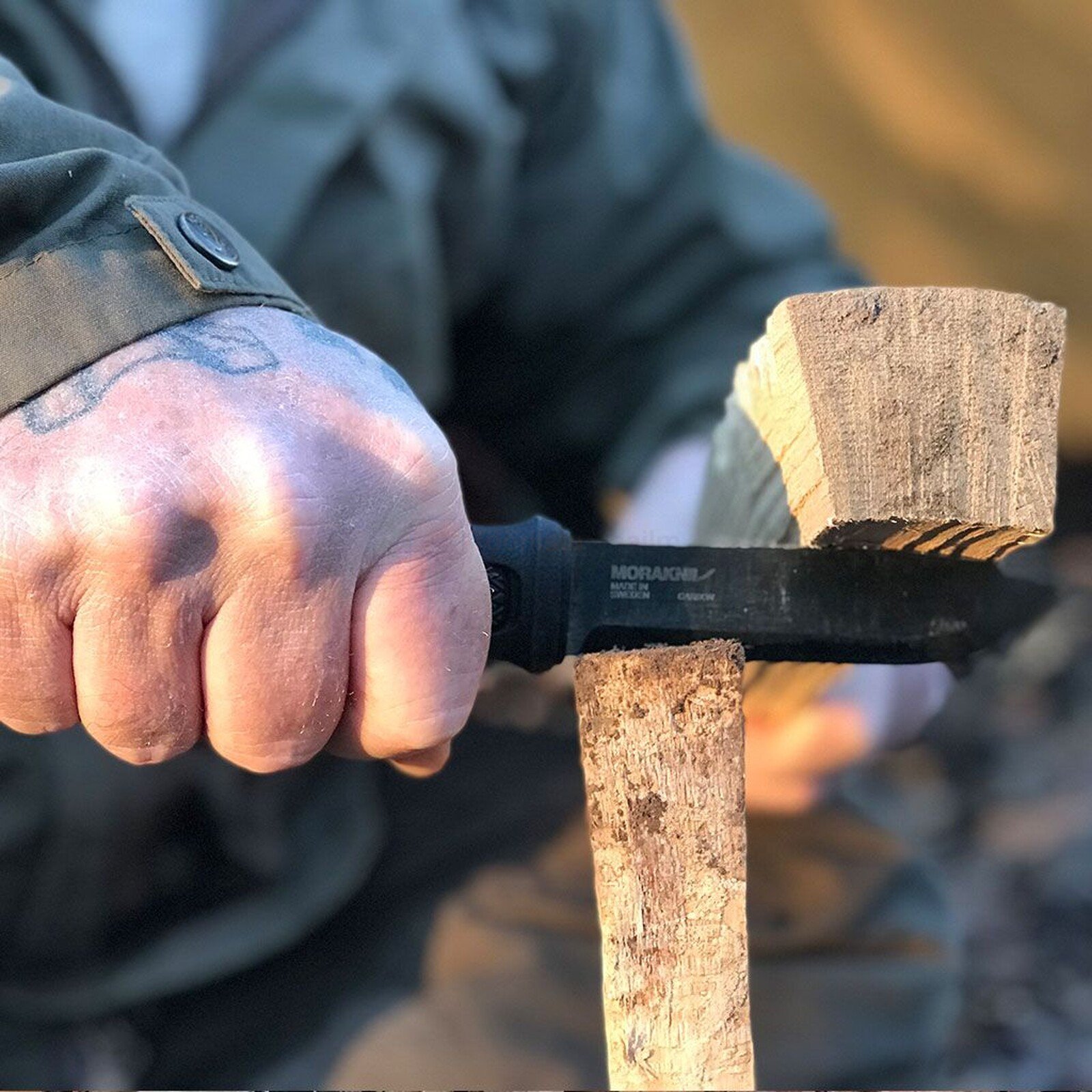 Pildil on näha, kuidas inimene kasutab MORAKNIV Garberg BlackBlade pussnuga puidu lõhkumiseks.