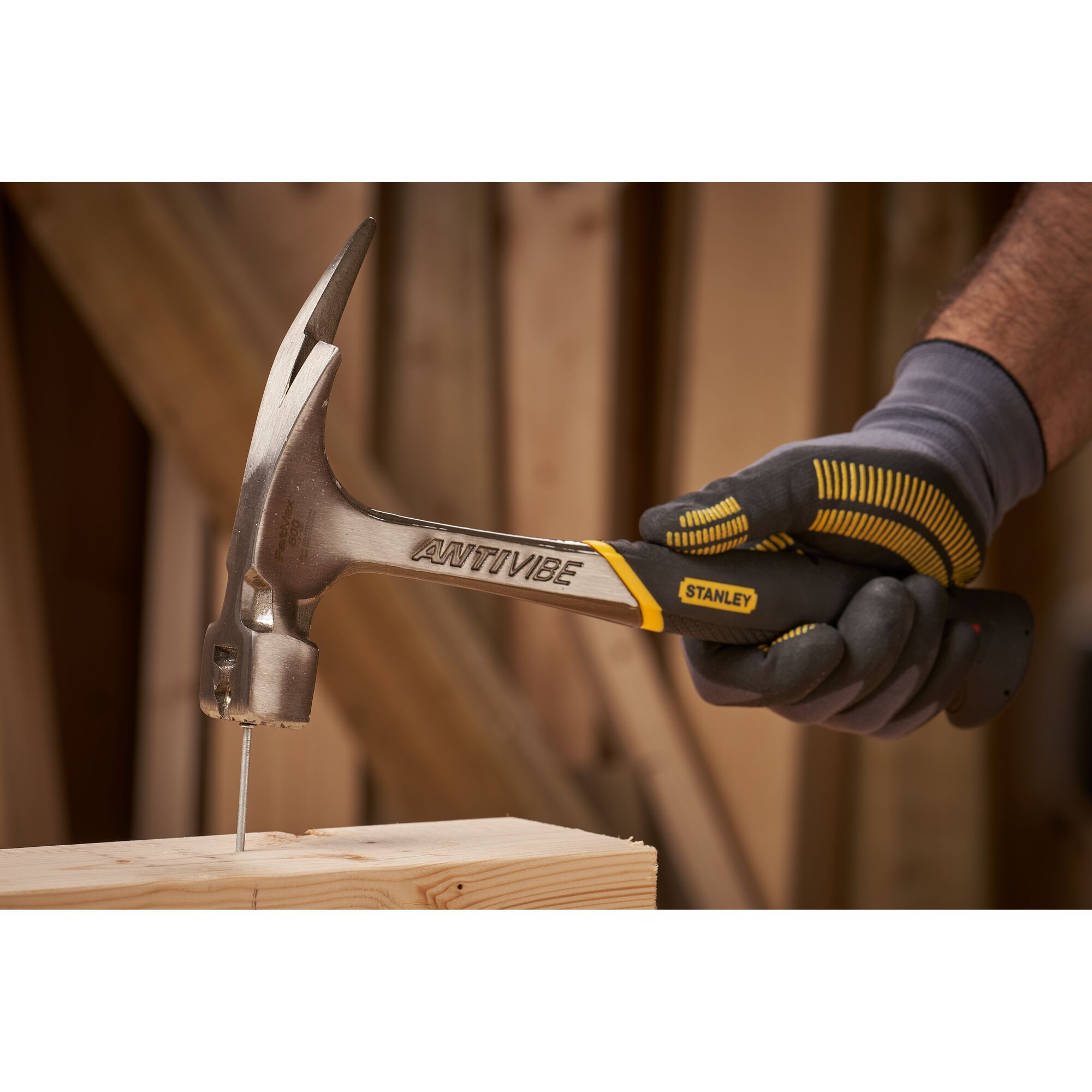 Pildil on näha Stanley puusepahaamer Fatmax Antivibe 600 g, mis on parasjagu naela puitu löömas.
