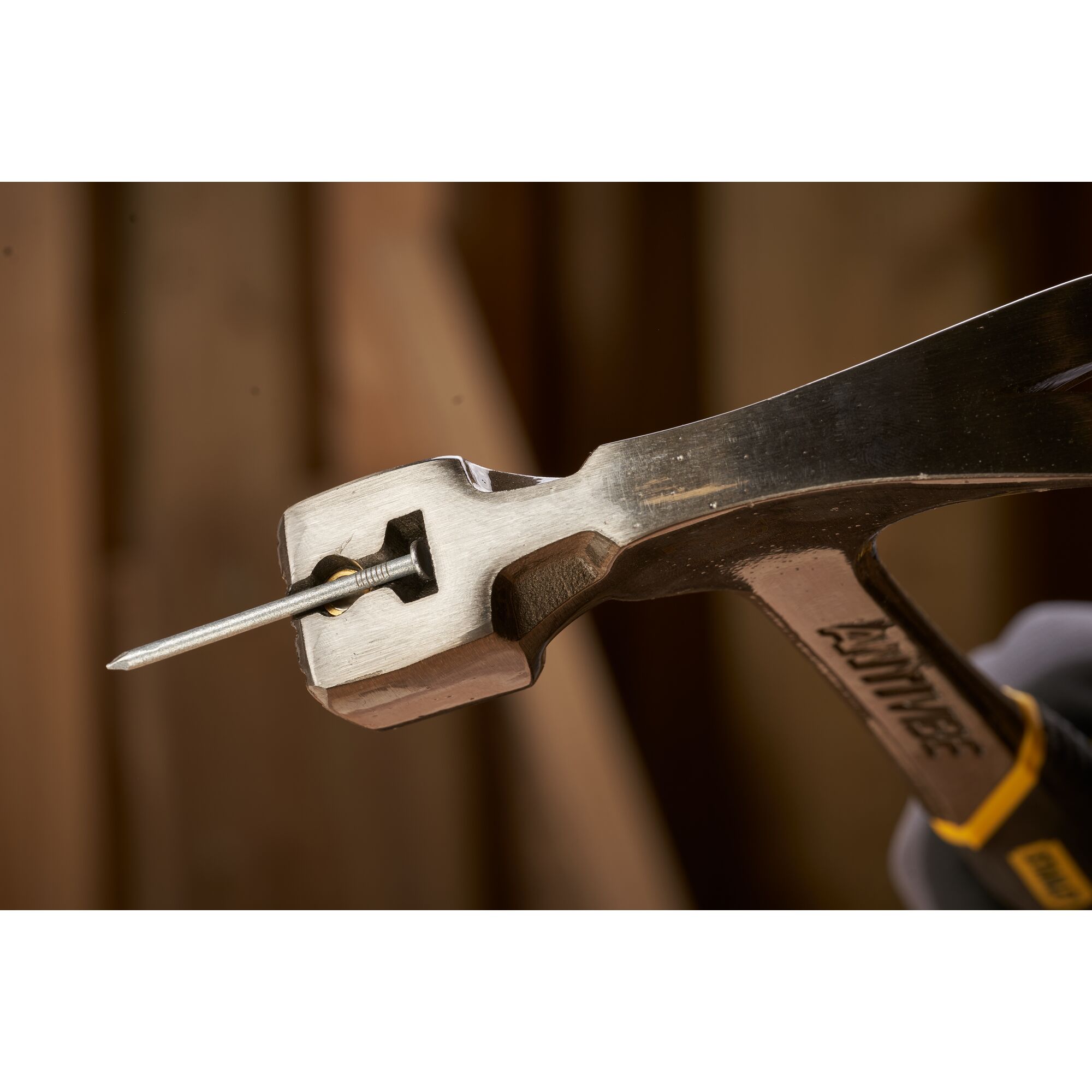 Pildil on detail Stanley puusepahaamri Fatmax Antivibe 600 g peast, millega on haamri abil kinni hoitud nael.