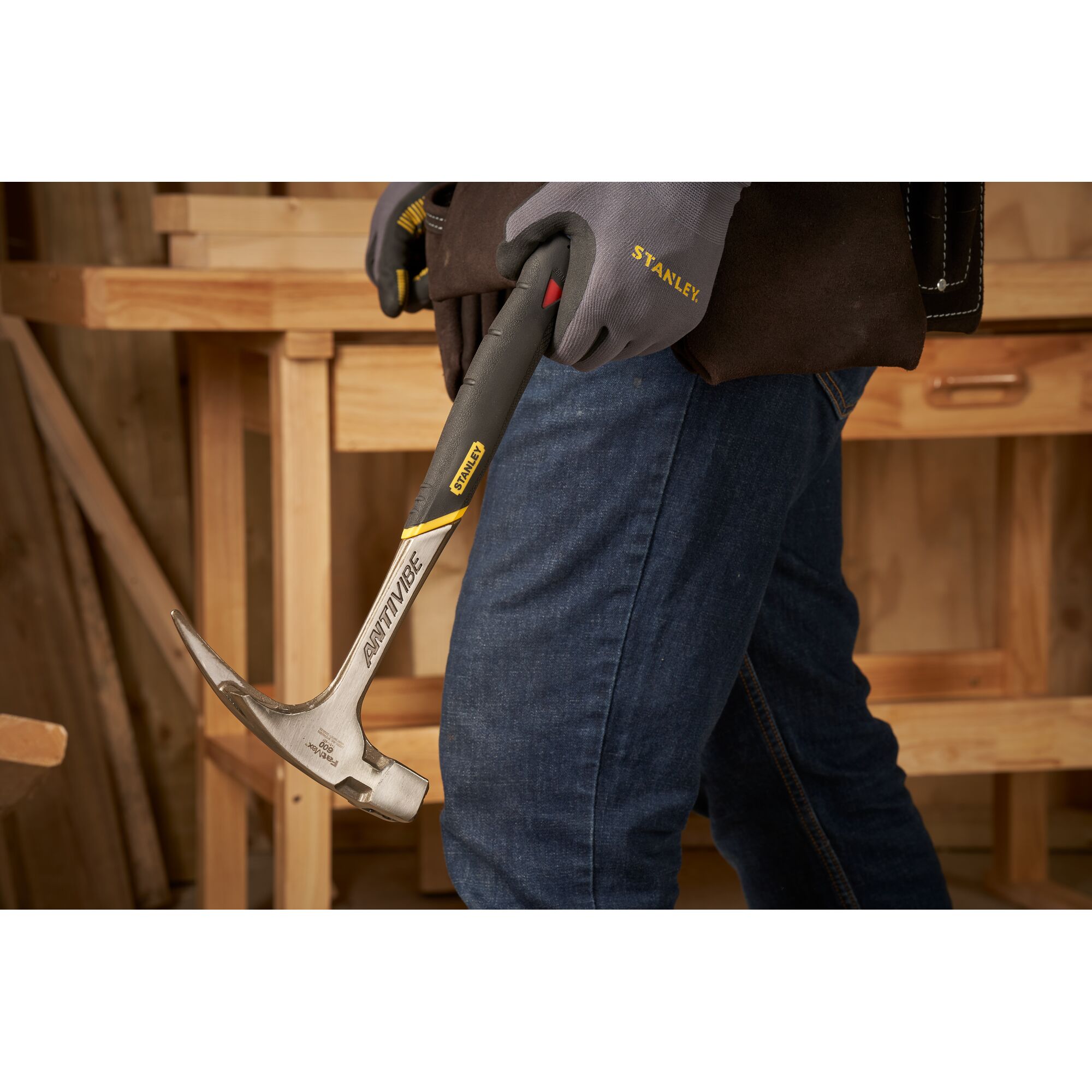Pildil näeb inimest, kes hoiab käes Stanley Fatmax Antivibe 600 g puusepahaamrit, ta kannab sinist teksapükse ja töökindaid.