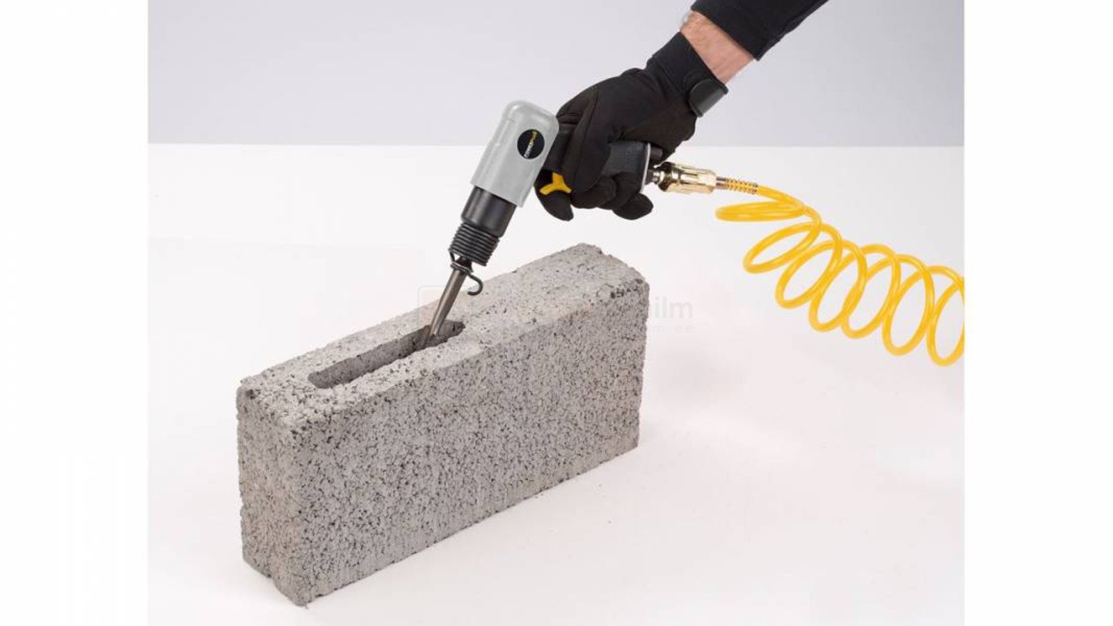 Pildil on näha, kuidas inimene kasutab Powerplus Air suruõhumeislit POWAIR0803 betoonploki lõhkumiseks.