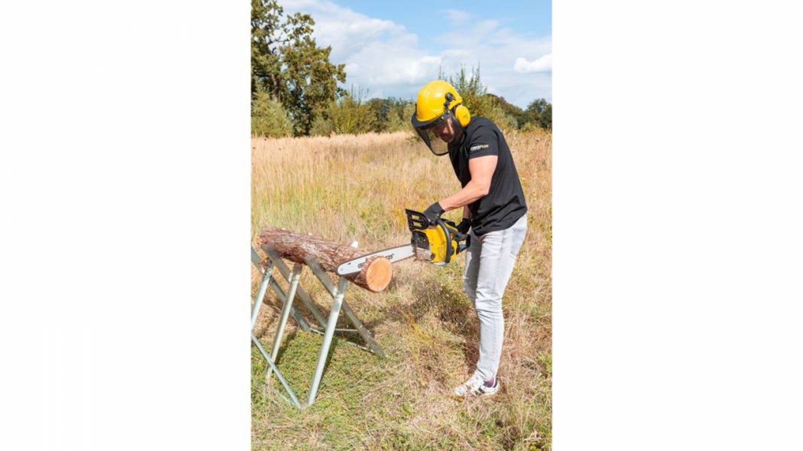 Pildil on näha inimene, kes kasutab Powerplus X mootorsaagi POWXG10231, et lõigata puidulõiku väljas.