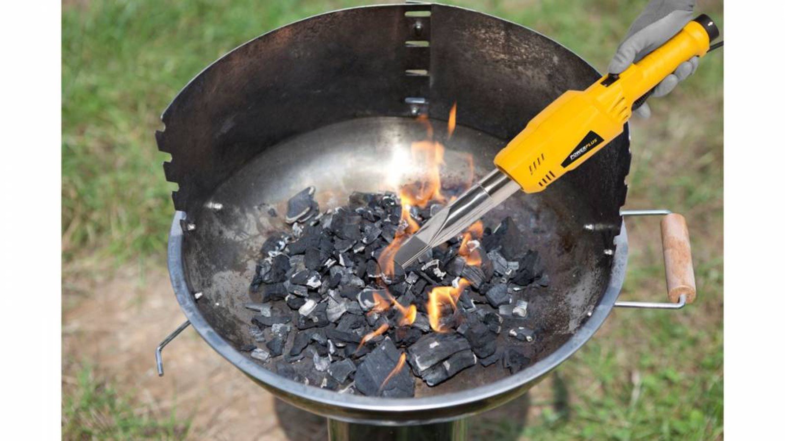 Pildil on näha, kuidas Powerplus X umbrohupõleti POWXG6611 abil süüdatakse grillis söed.