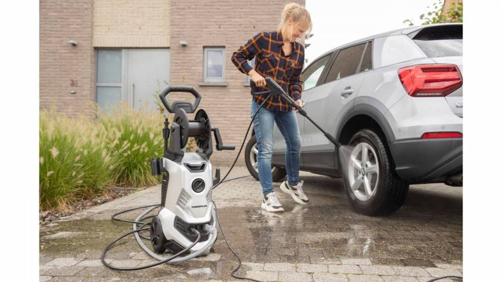 Pildil on naine, kes peseb autot survepesuriga Powerplus X POWXG90416.