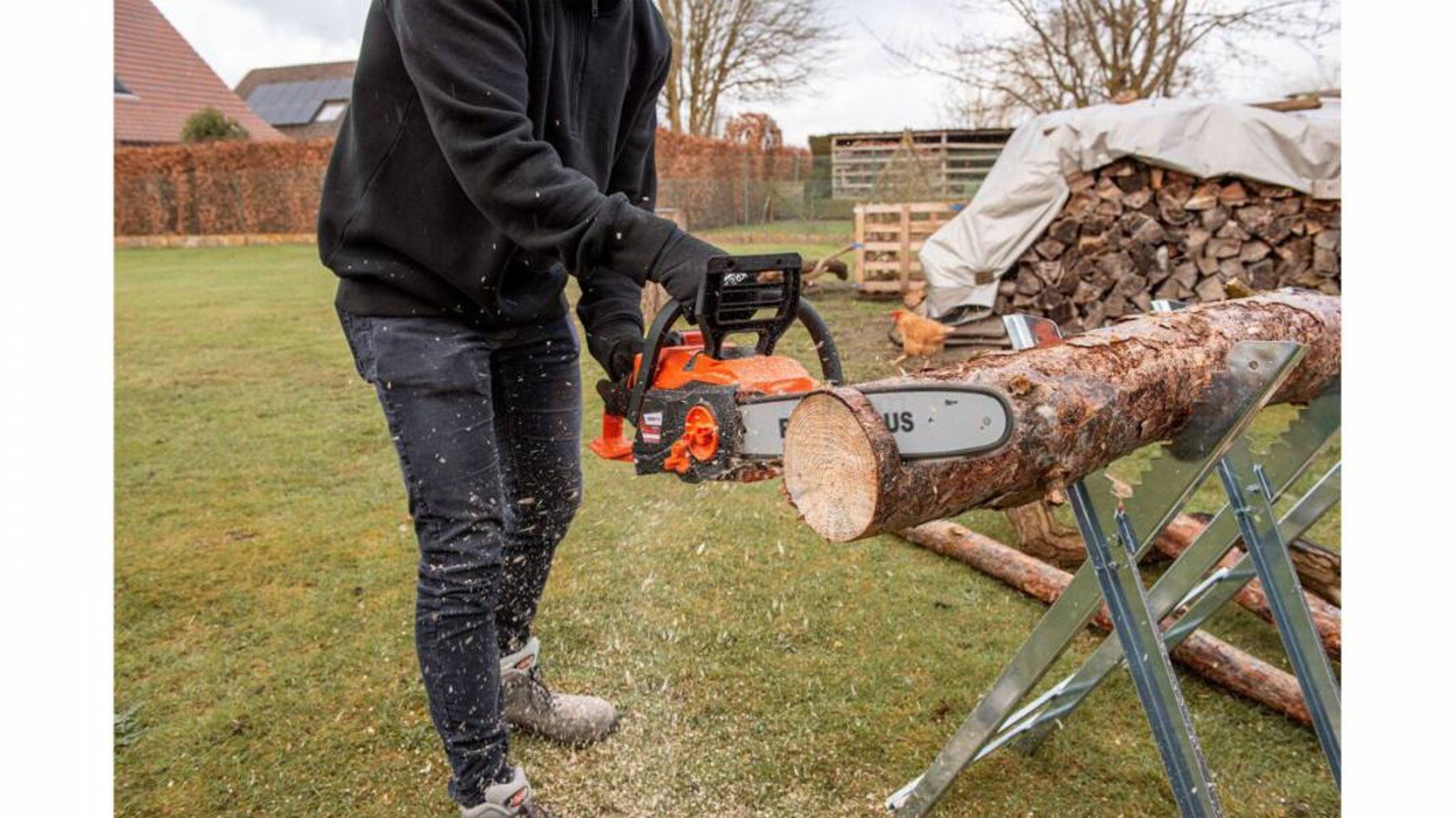 Pildil on näha inimene, kes kasutab Powerplus Dualpower akukettsaagi, lõigates puidust palki.