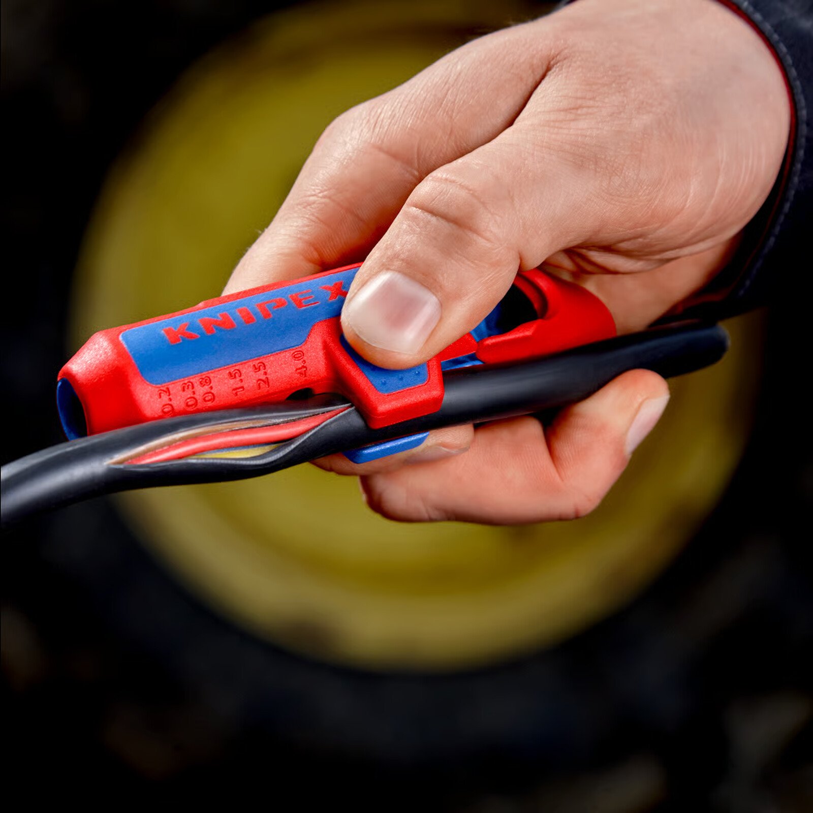 Pildil on näha, kuidas käsi kasutab Knipex kaablikoorijat ErgoStrip® PV 0,2 - 4 mm² kaabli koorimiseks.