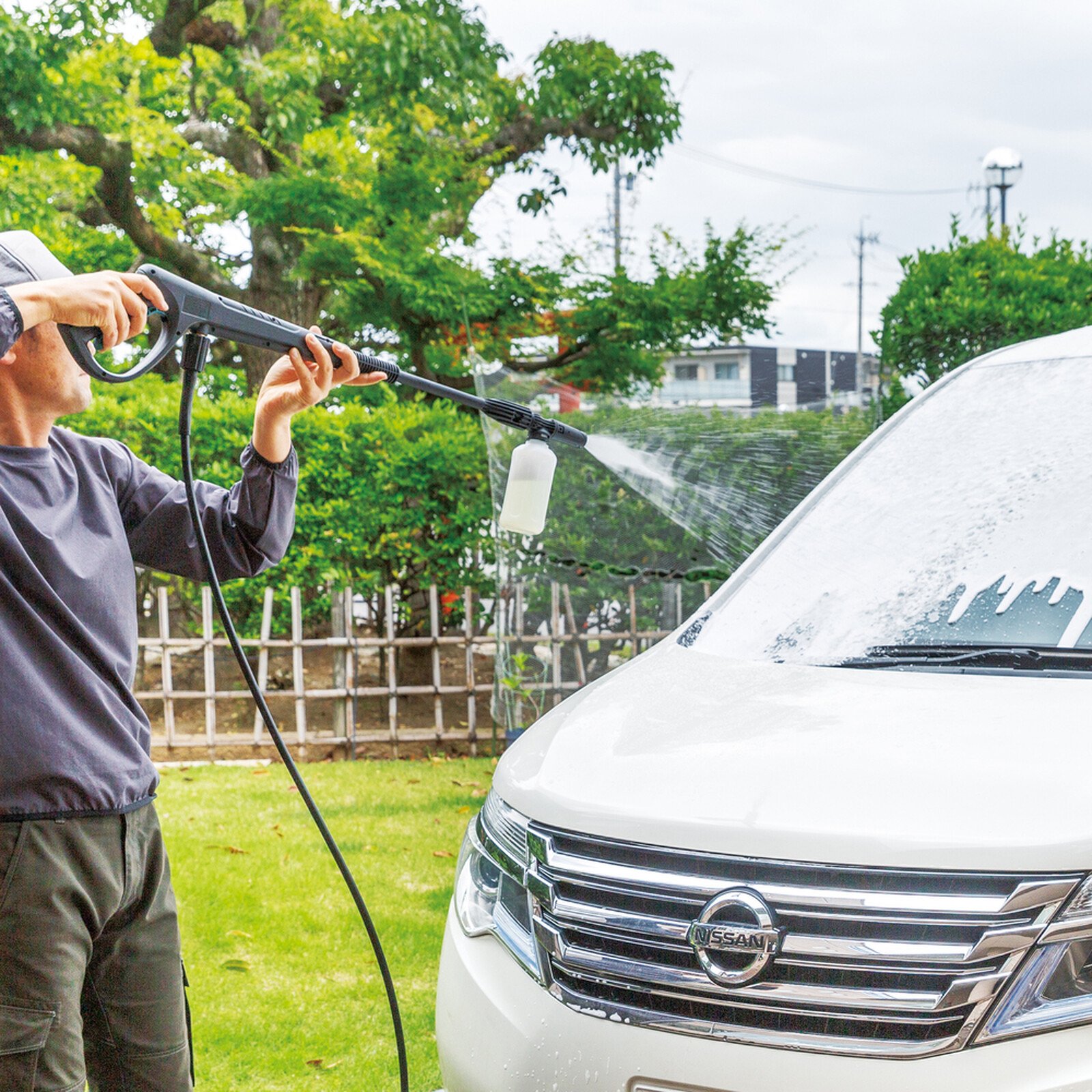 Pildil on mees, kes kasutab Makita vahuotsikut, et pesta valget autot.