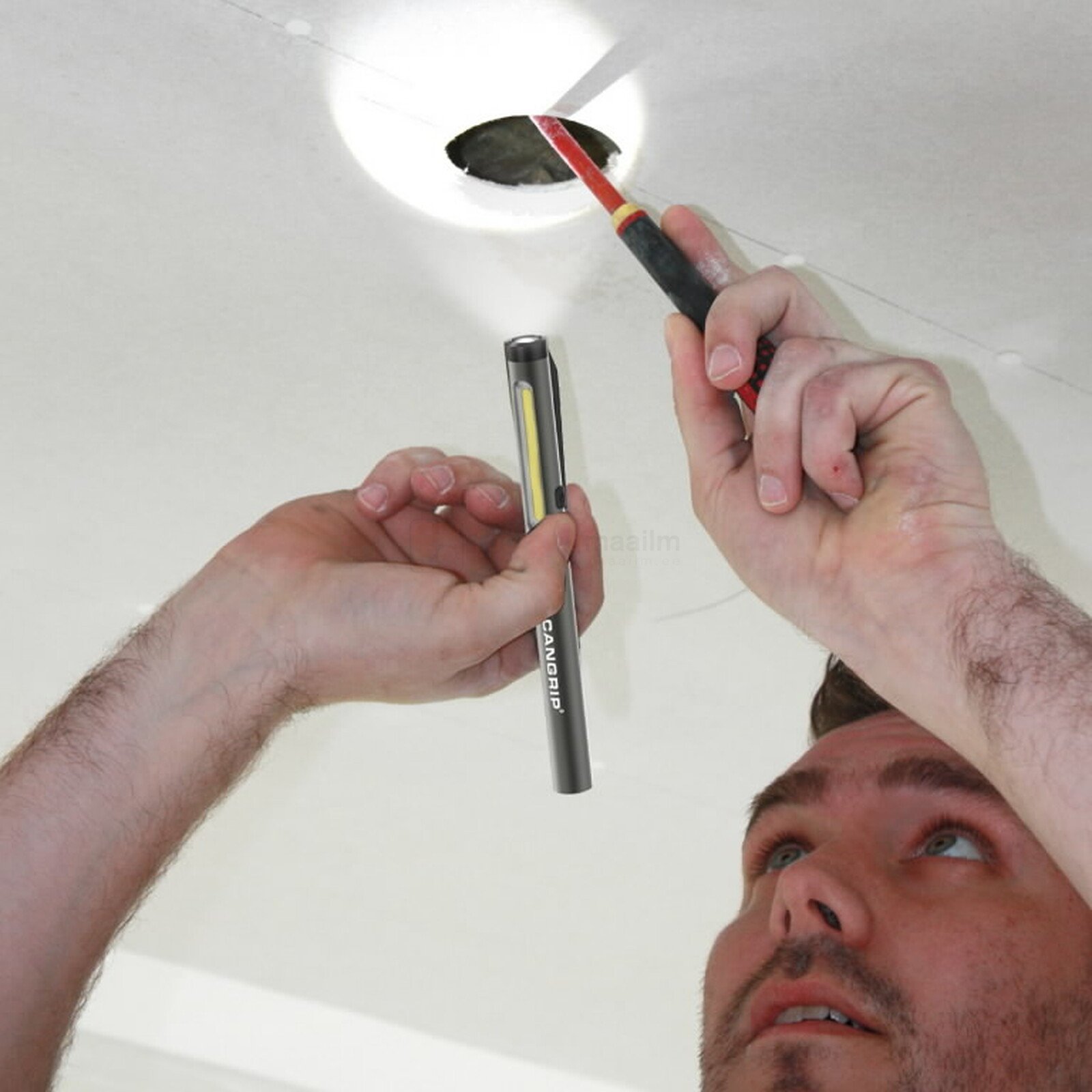 Pildil on mees, kes kasutab SCANGRIP taskulampi WORK PEN 200 R ja võtmehoidja-valgustit FLASH MICRO R, et valgustada ja...