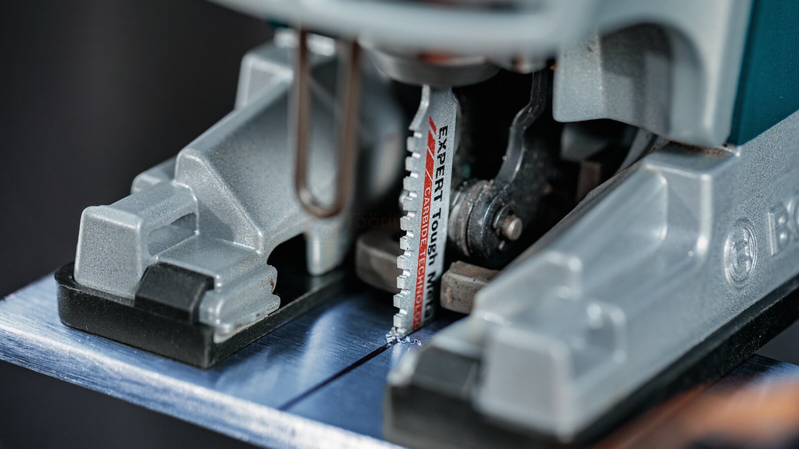 Pildil on näha Bosch tikksaag, mis lõikab metalli, ning selle terasid.