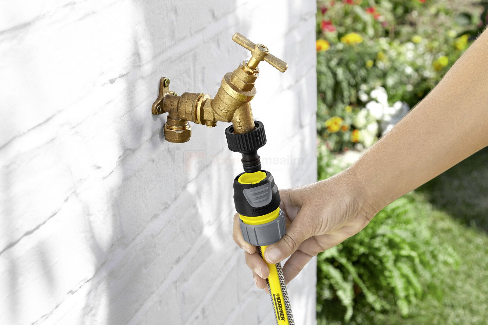 Pildil on näha, kuidas inimene ühendab Kärcher universaalset vooliku üleminekut Premium 1/2″, 5/8″, 3/4″ kraaniga, et...