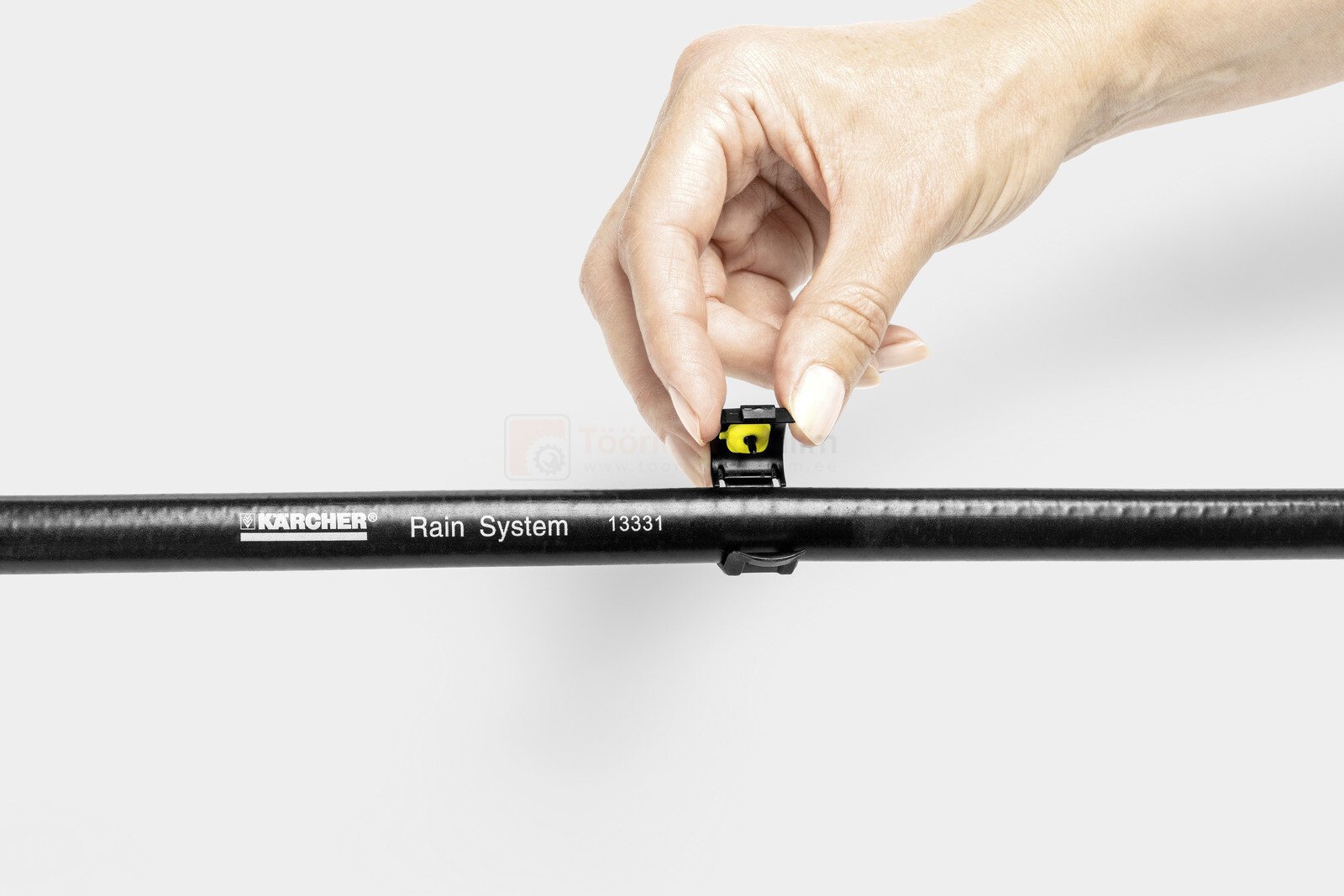 Pildil on näha, kuidas inimene paigaldab Kärcheri tihendusmuhvi mustale torule.