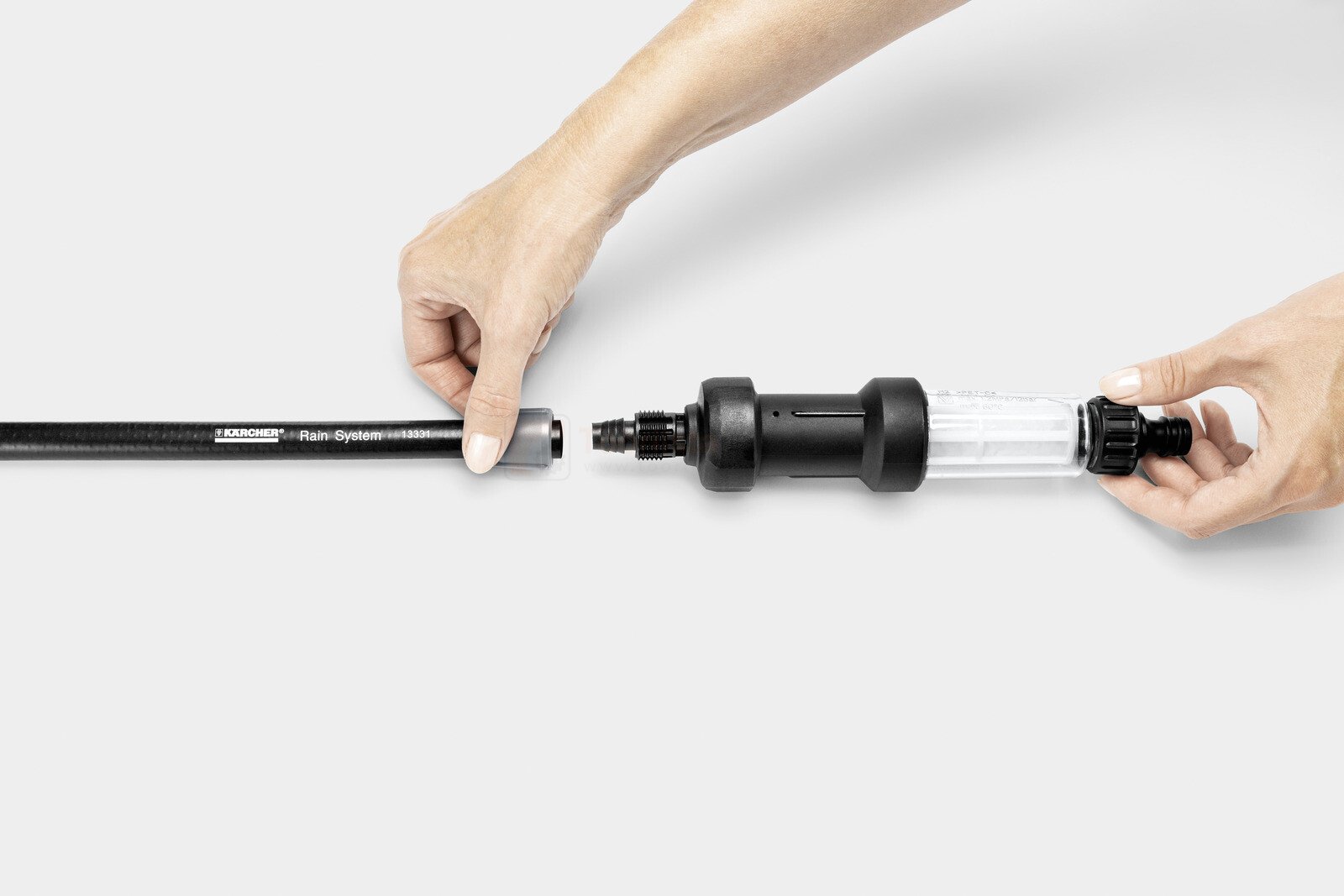 Pildil on näha, kuidas inimene ühendab Kärcheri niisutusvooliku komplekti 1/2" 20 m osi.