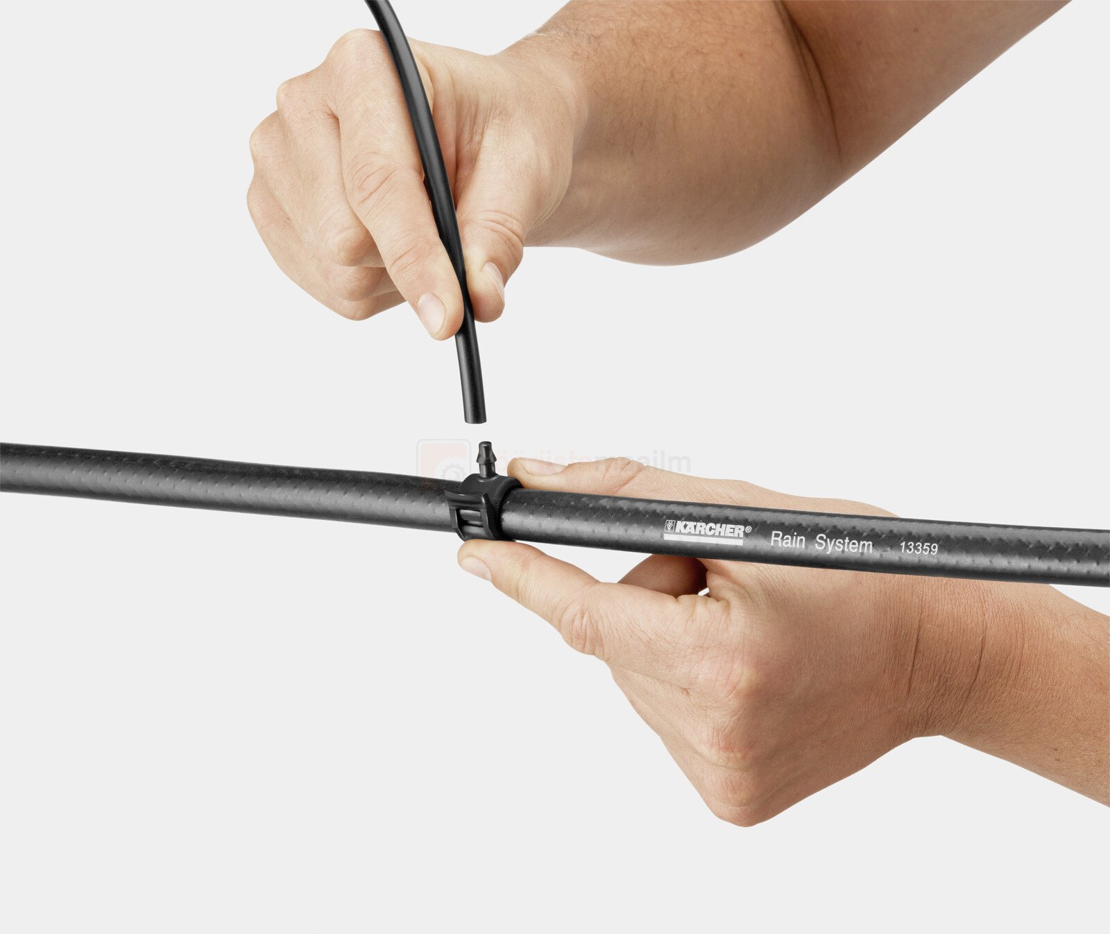 Pildil on näha, kuidas inimene ühendab Kärcheri potitaimede kastmise komplekti toru.