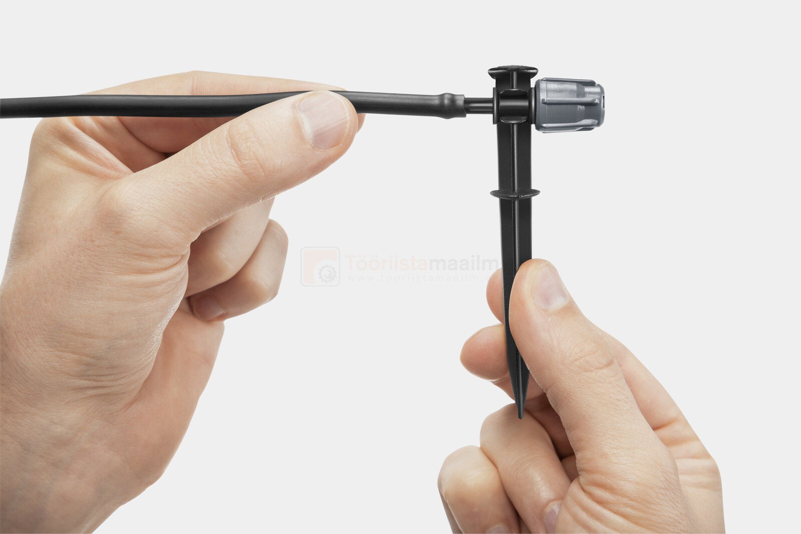 Pildil on näha, kuidas käed paigaldavad Kärcheri potitaimede kastmise komplekti, mis koosneb torust, tilgutist ja maasse...