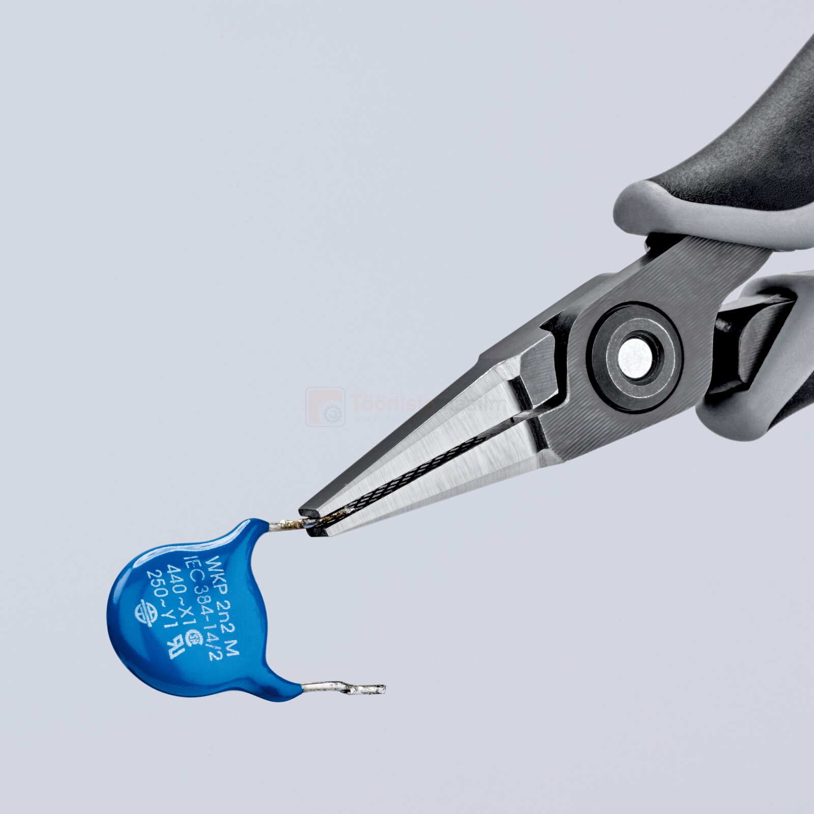 Pildil on näha, kuidas Knipex elektrooniku koonusmokktangid 130 mm, ESD hoiavad kinni sinise komponendi juhtmest.