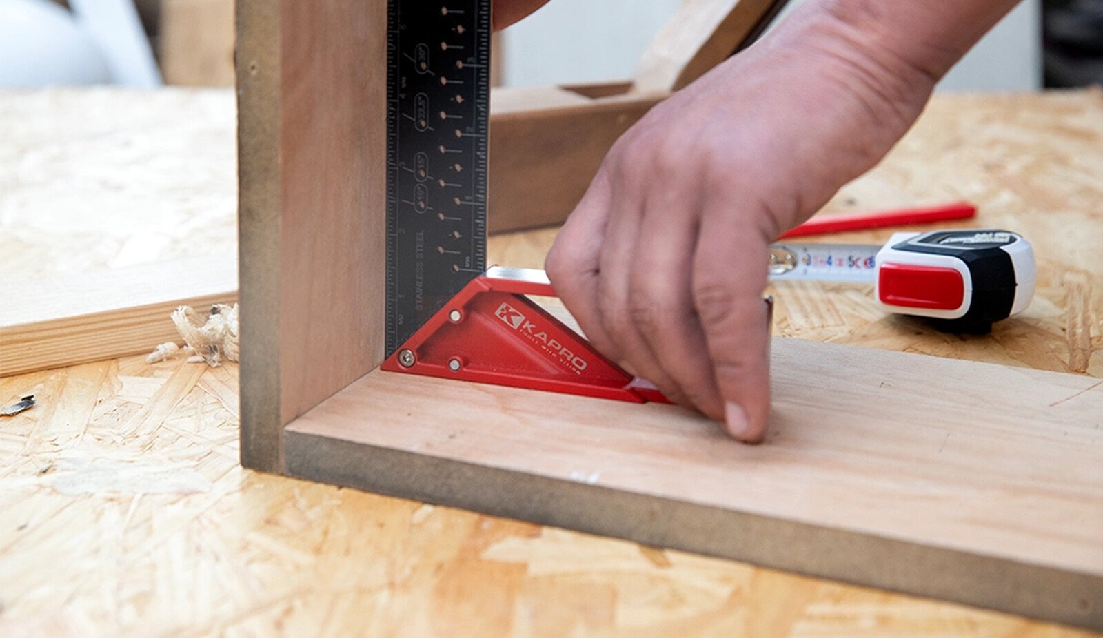 Pildil on näha, kuidas inimene kasutab Kapro märkimise nurgikut puidutöö tegemisel, et kontrollida kahe detaili täisnurksust.