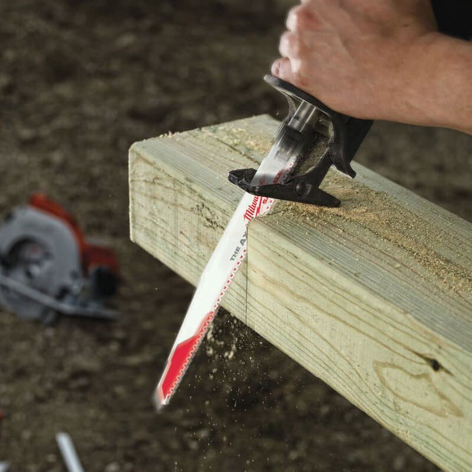 Pildil on näha, kuidas keegi kasutab Milwaukee otssaetera AX 300 mm 5 TPI saetera, et lõigata puitu.
