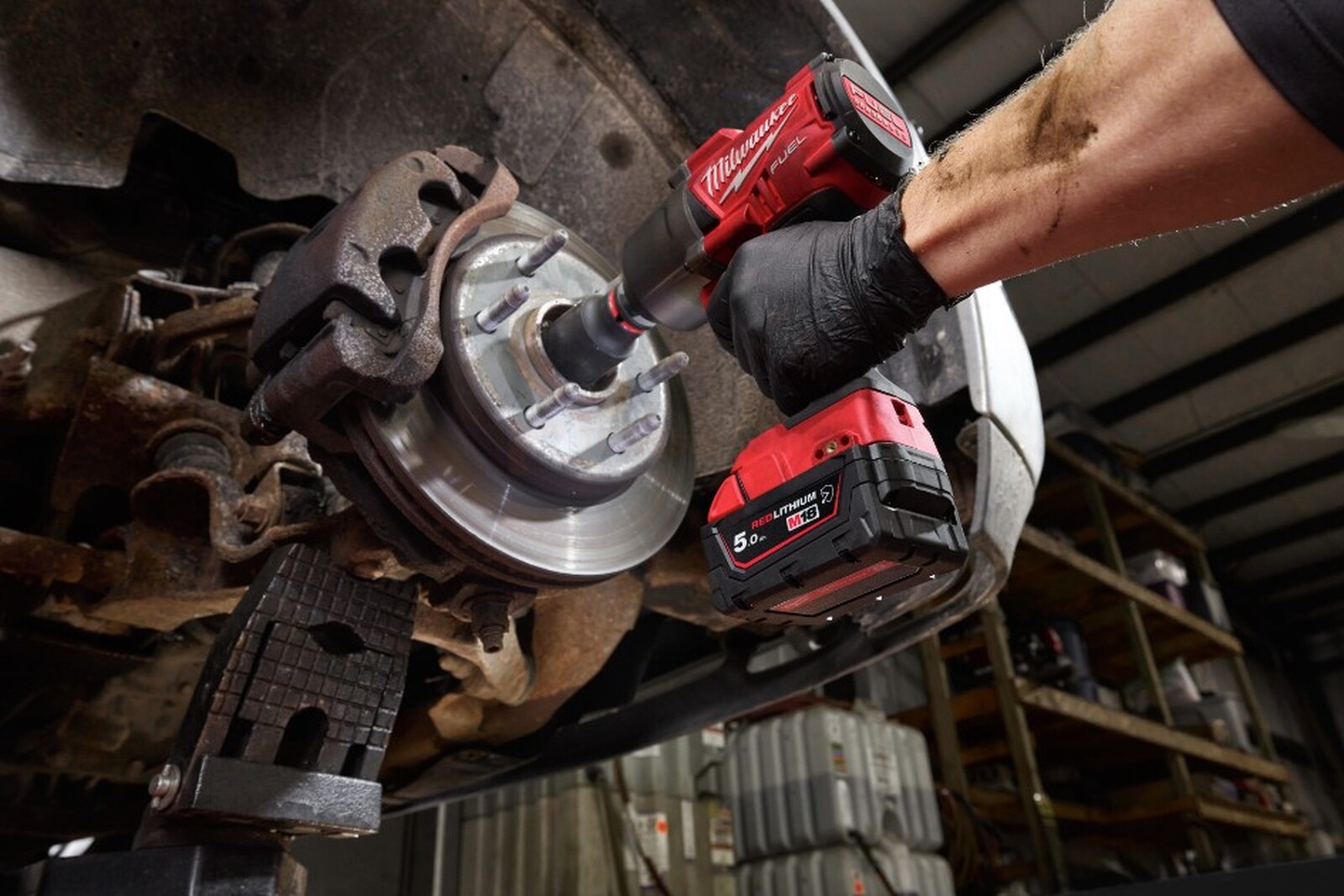 Pildil on näha, kuidas mehaanik kasutab Milwaukee M18 aku löökmutrikeerajat auto pidurisüsteemi kallal.