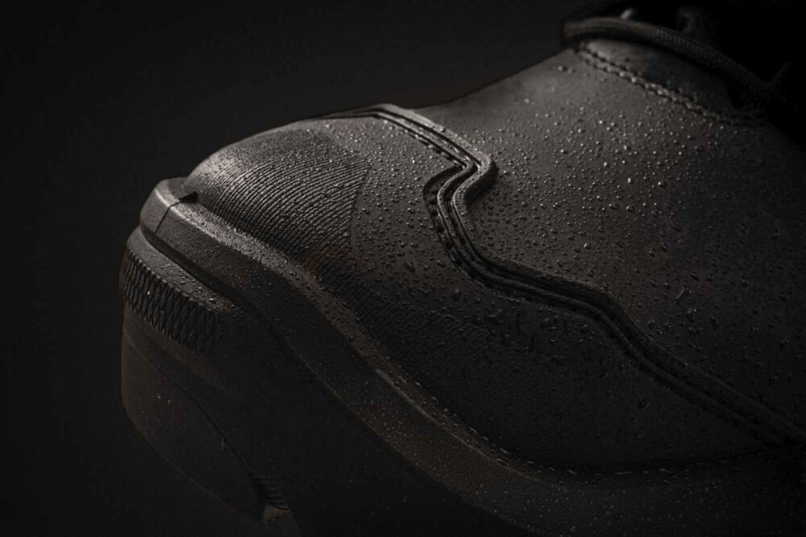 Pildil on detailne vaade mustadele Milwaukee Armourtred™ S7S turvasaabastele, mille pealispinnale on kogunenud veepiisad.