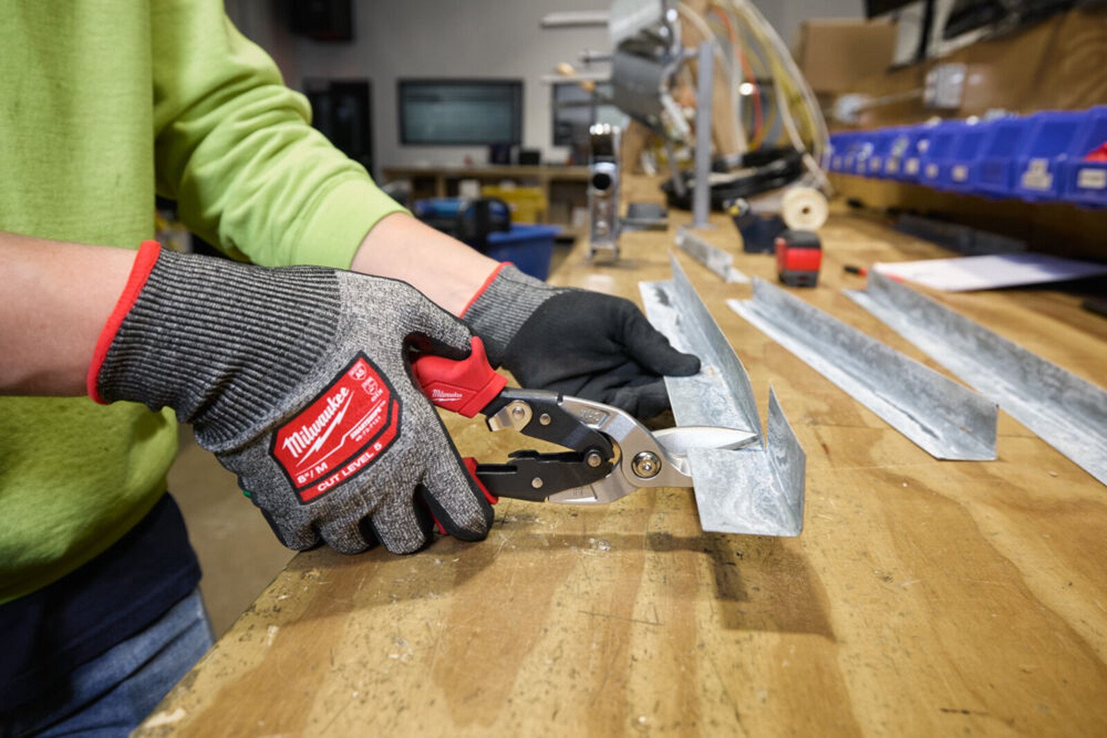 Pildil on inimene, kes kasutab Milwaukee plekikäärid, parem, et lõigata metalli.