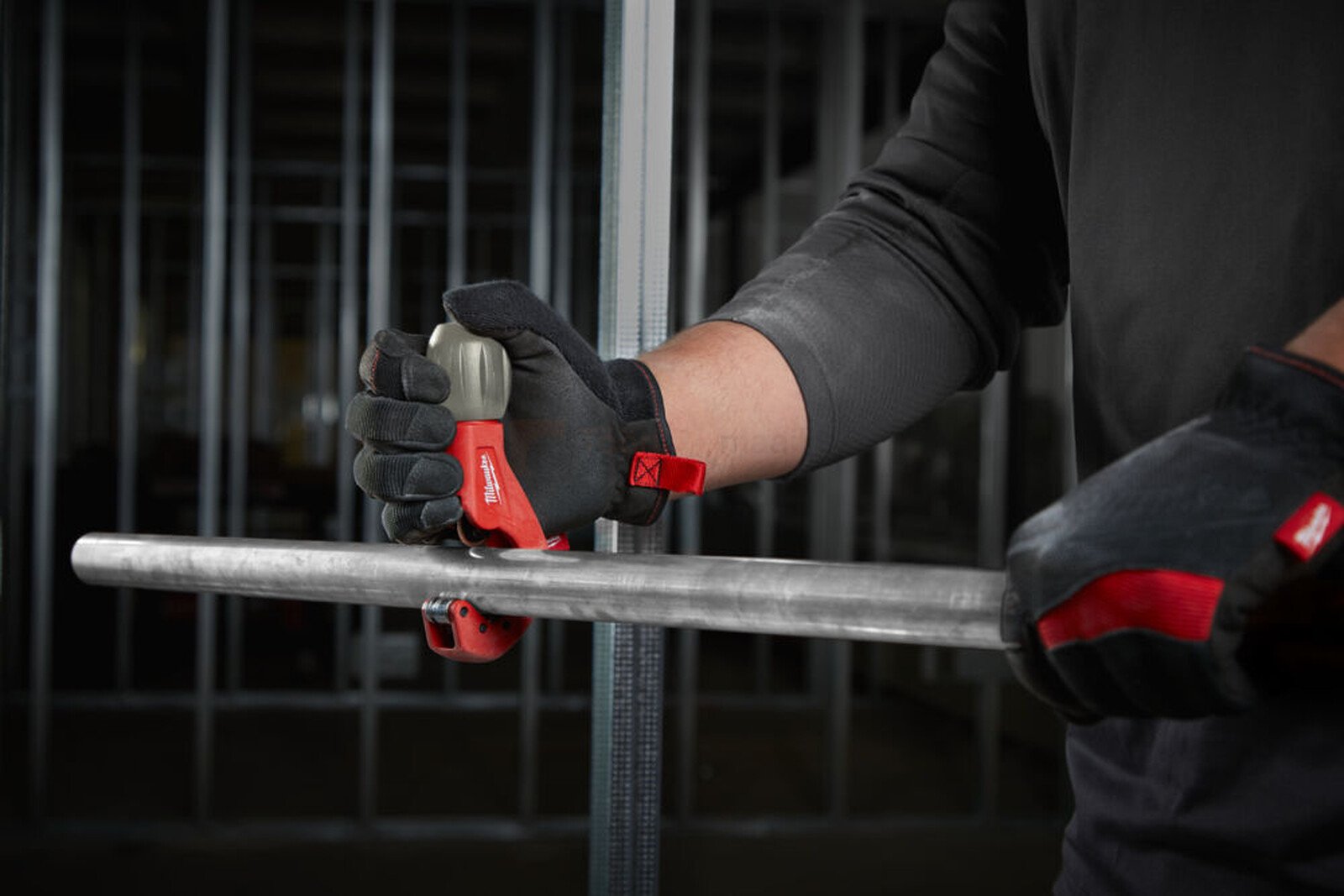 Pildil on mees, kes kasutab Milwaukee torulõikurit 3-29 mm INOX torudele, et lõigata metalltoru.