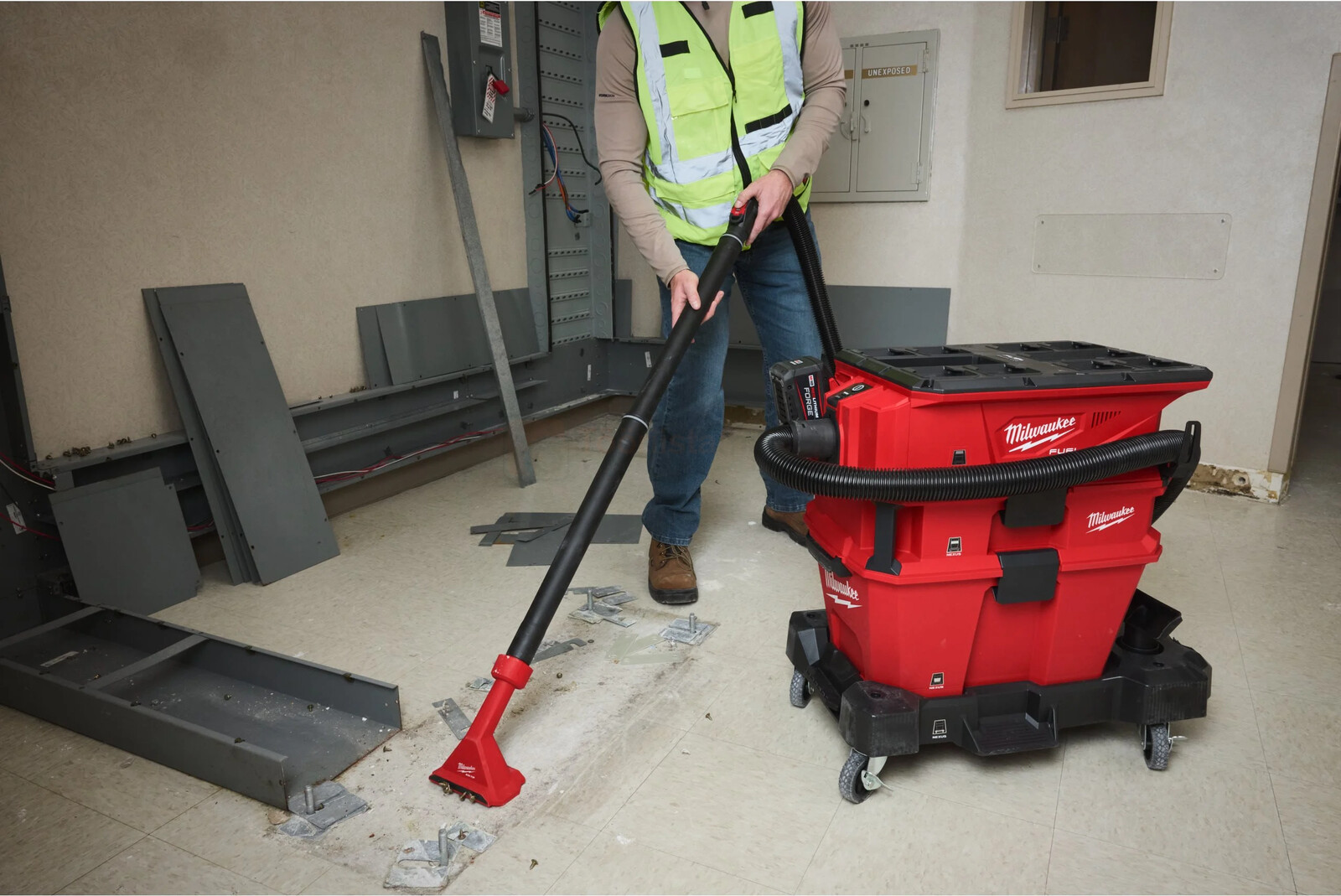 Pildil on ehitustöölise poolt kasutatav Milwaukee tolmueraldaja, mis on kinnitatud tolmuimejale, samal ajal kui ta...