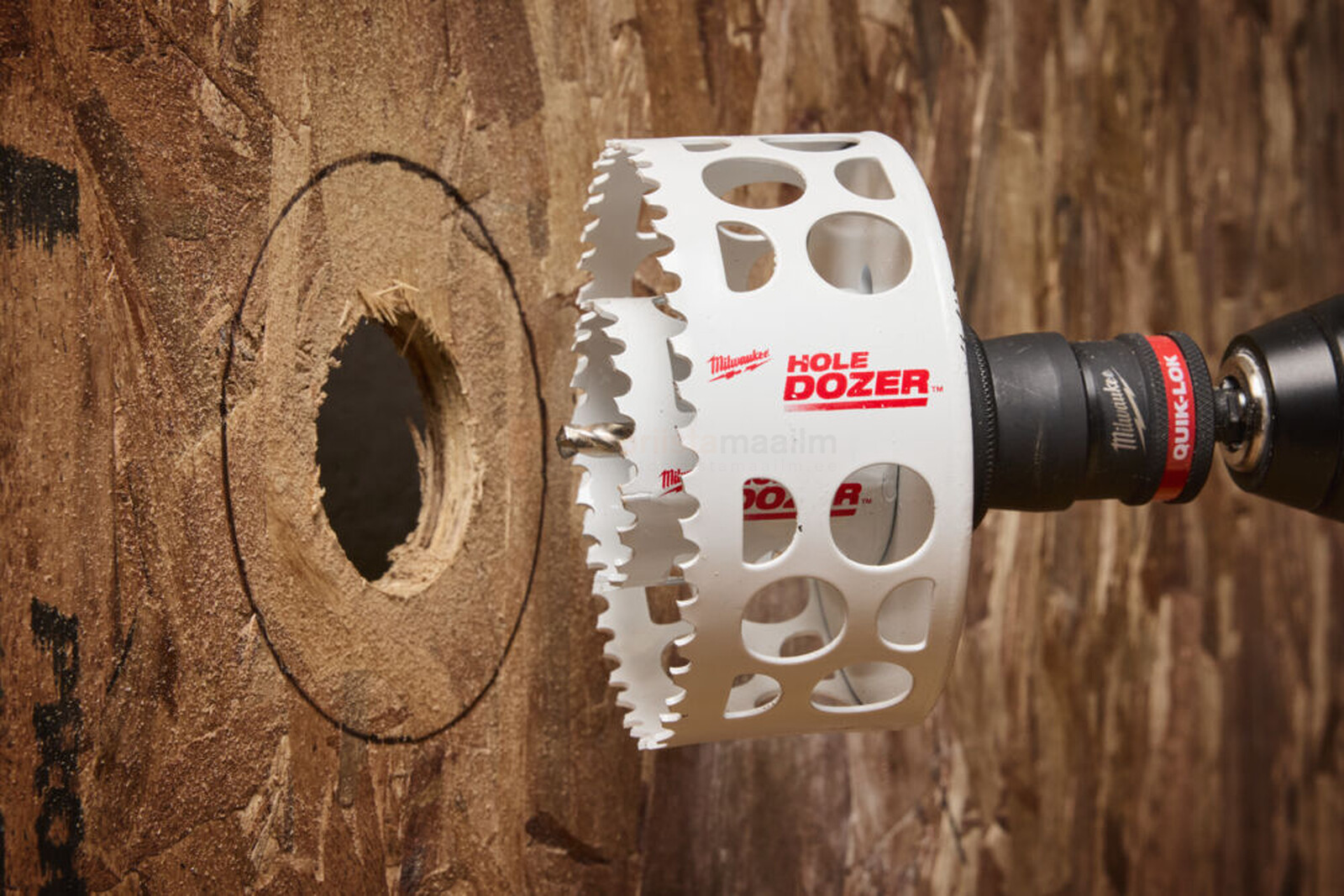 Pildil on Milwaukee augusaega tehtud auk puidus, kasutades augusae ava suurendusadapterit.
