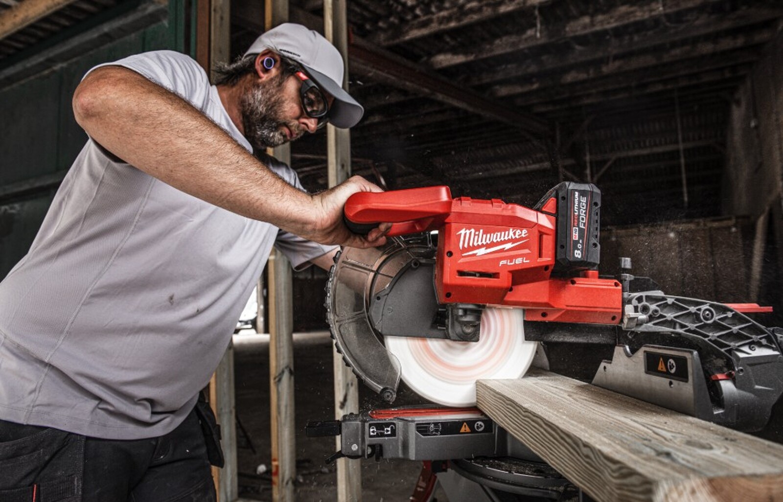 Pildil on mees, kes kasutab Milwaukee M18 FMS254 akutoitega miiusaepinki, lõigates puitu.