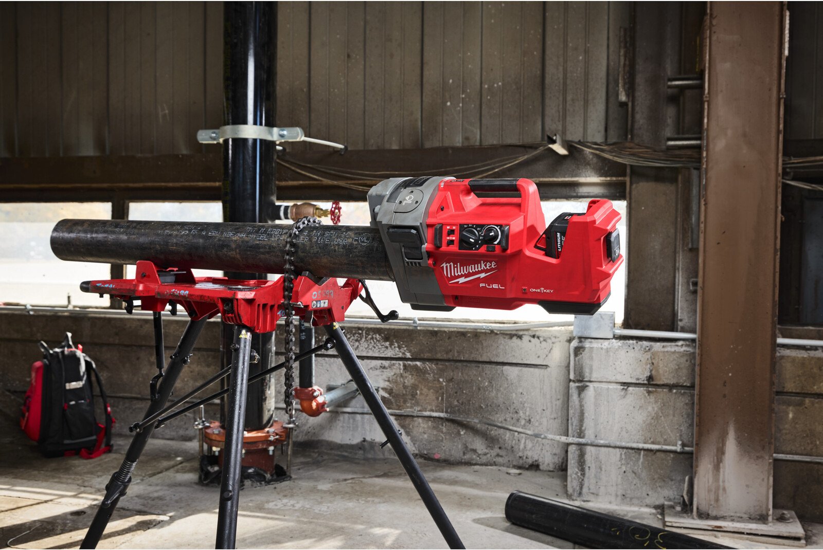 Pildil on Milwaukee akutoitel toruvaltsija, mis on paigaldatud statiivile ja valtsib suurt toru.