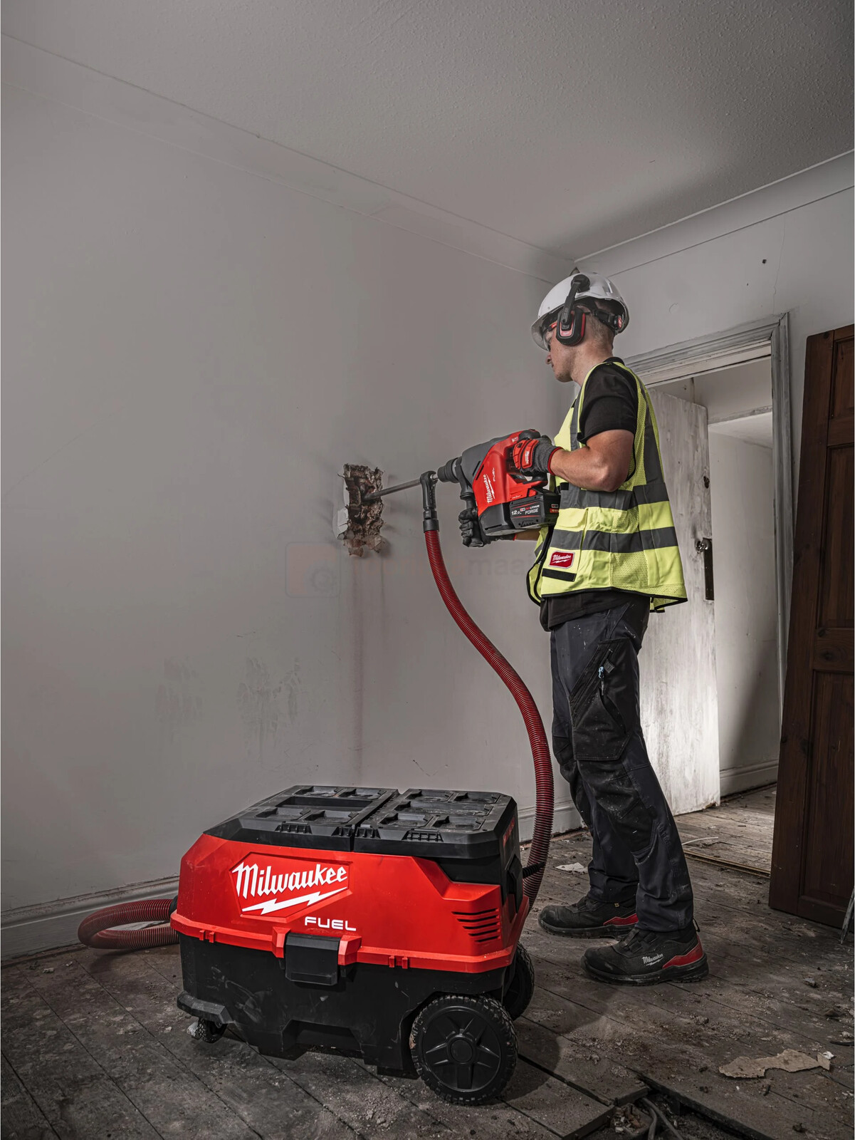 Pildil on ehitustööline, kes kasutab Milwaukee akupuurvasarat M18 FHACO540-0C seina lammutamiseks, samal ajal kui...