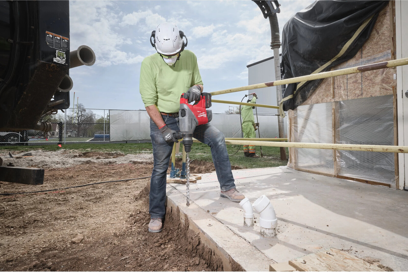 Pildil on ehitustöölise poolt kasutatav Milwaukee akupuurvasar M18 FHACO745-0C, kes puurib betooni ehitusplatsil.