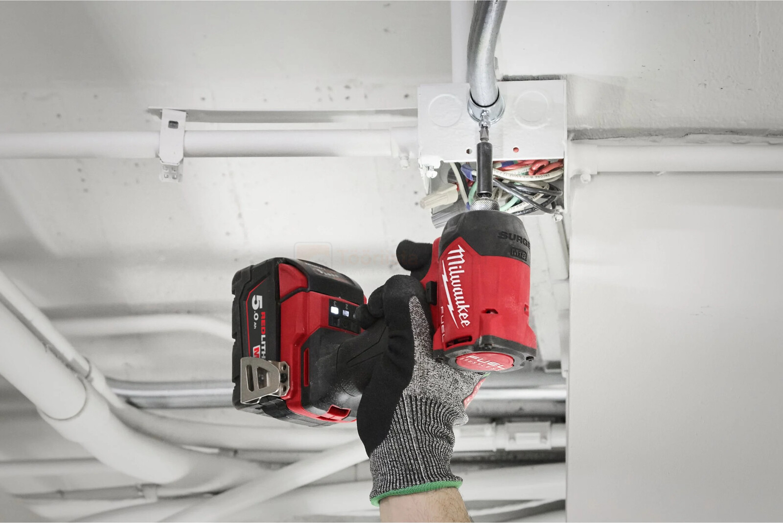 Pildil on näha, kuidas inimene kasutab Milwaukee M18 FIDRQ-0X hüdraulilist akulöökkruvikeerajat, et kruvida midagi...