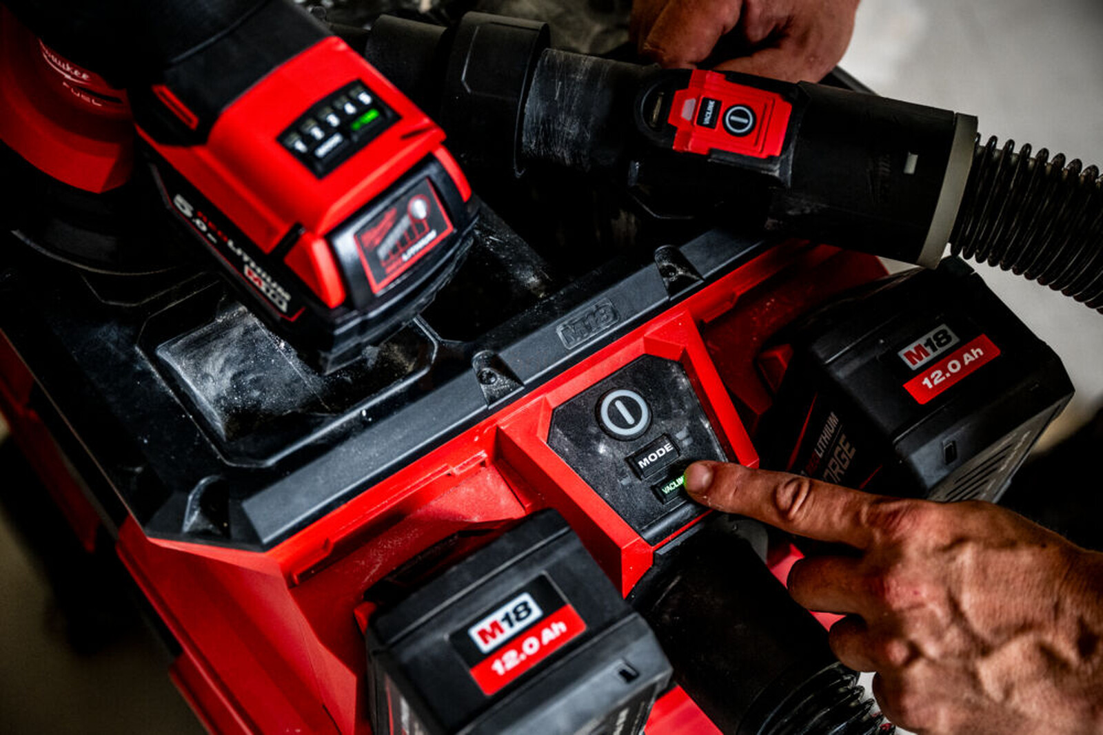 Pildil on Milwaukee akuga vee- ja tolmuimeja, millel on mitu M18 akut ja mis on ühendatud teiste Milwaukee tööriistadega.