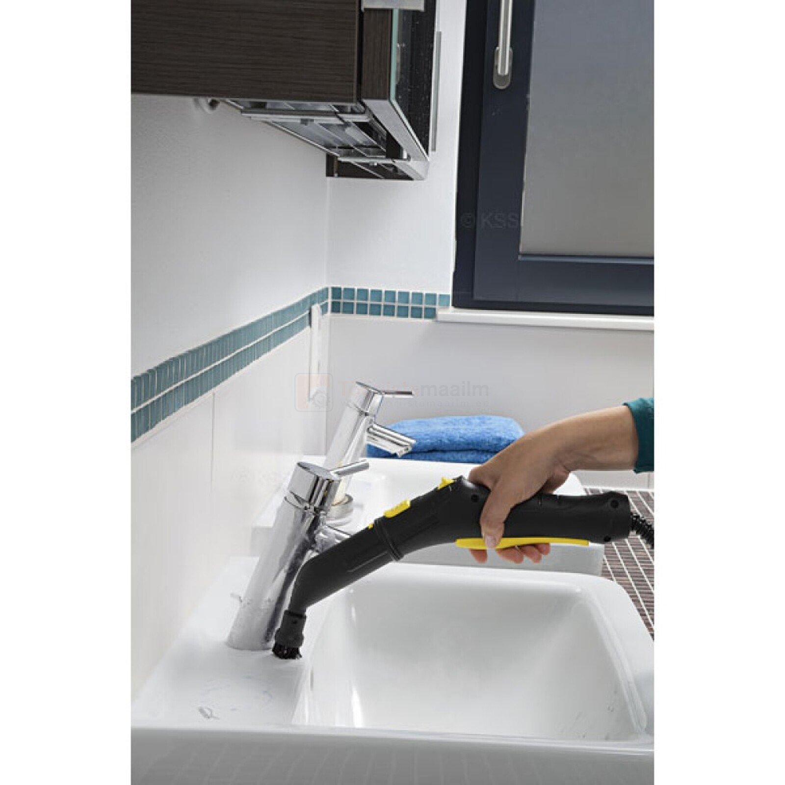 Pildil on näha, kuidas inimene kasutab Kärcheri punktotsikut aurupesurile, et puhastada valamu kraanikaussi.