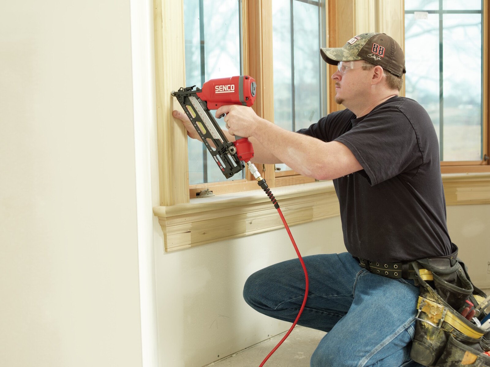 Pildil on mees, kes kasutab SENCO FinishPro42XP liistunaelapüstolit, et kinnitada liiste akna ümber.