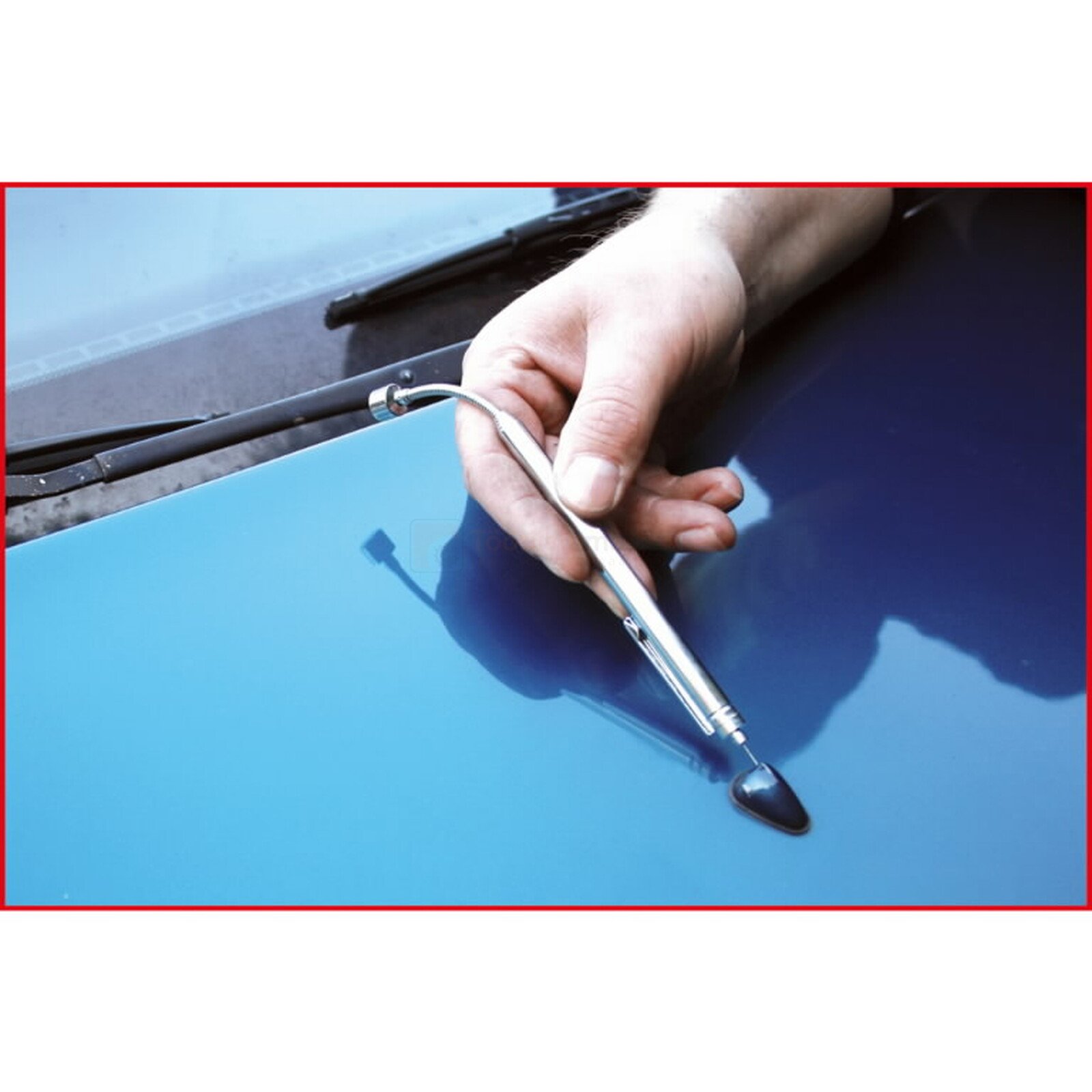 Pildil on näha kätt, mis hoiab KS Tools teleskoopmagnetit/pesudüüside puhastustööriista, mida kasutatakse auto sinisel...