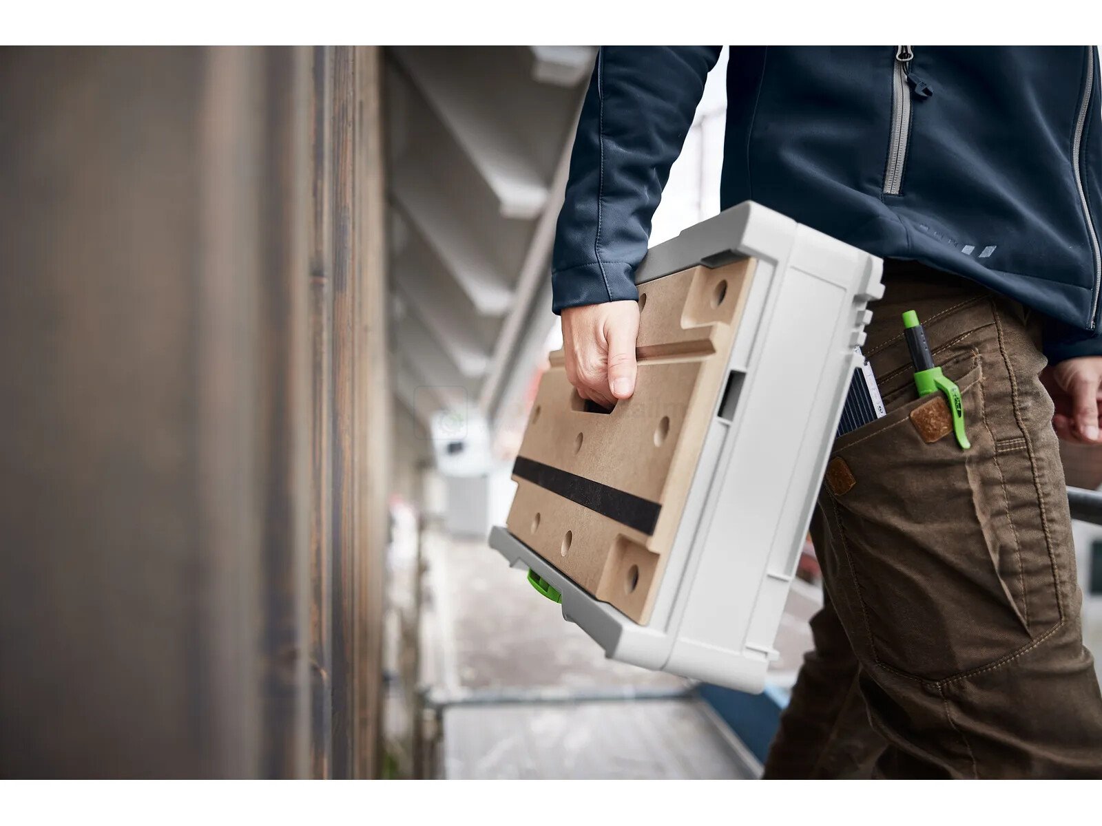 Pildil on inimene, kes kannab Festool mobiilset tööpinki-Systainer³ SYS3-MFT M 112.