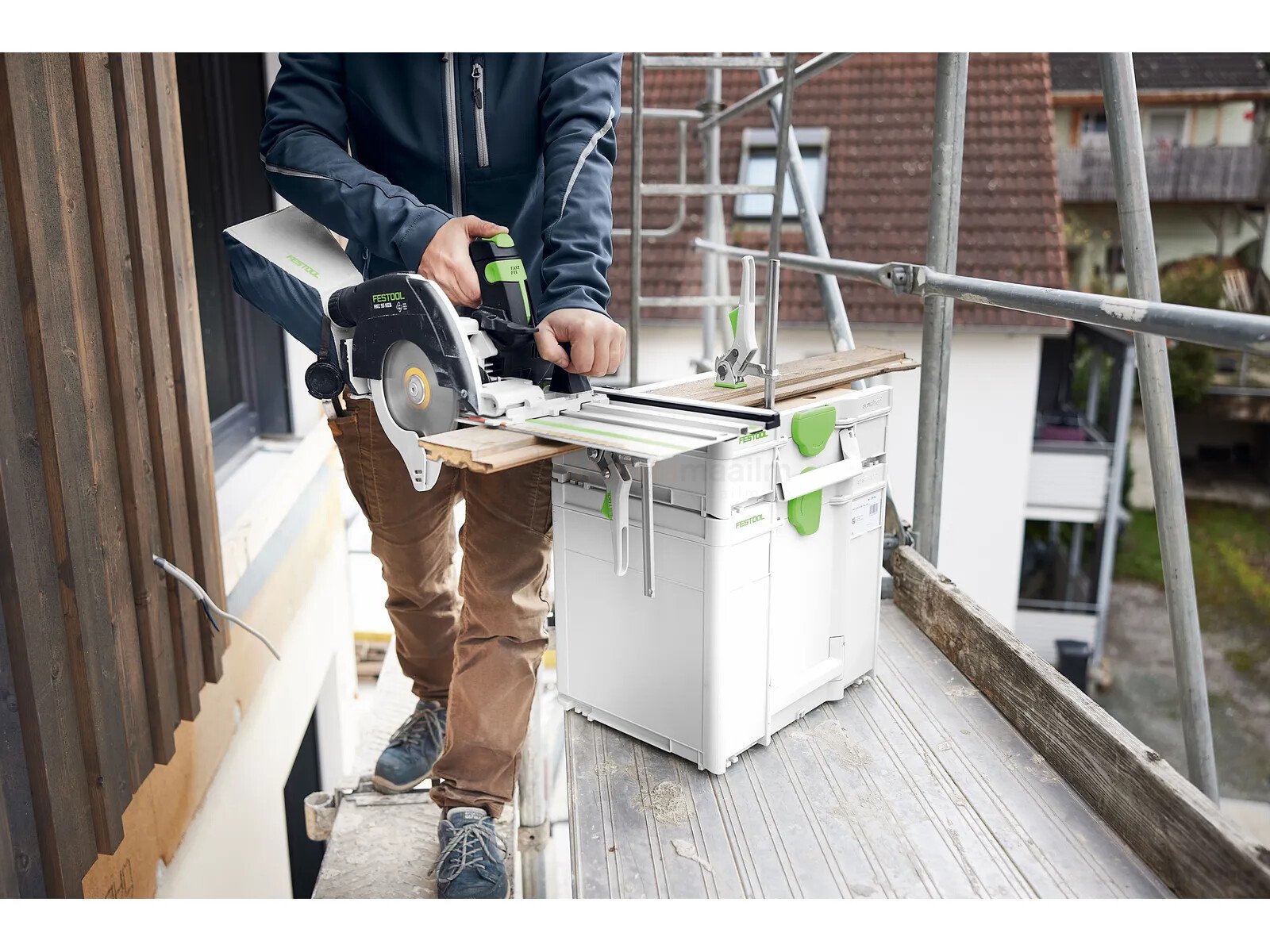 Pildil on mees, kes kasutab Festool mobiilset tööpinki-Systainer³ SYS3-MFT M 112, et lõigata puitu.