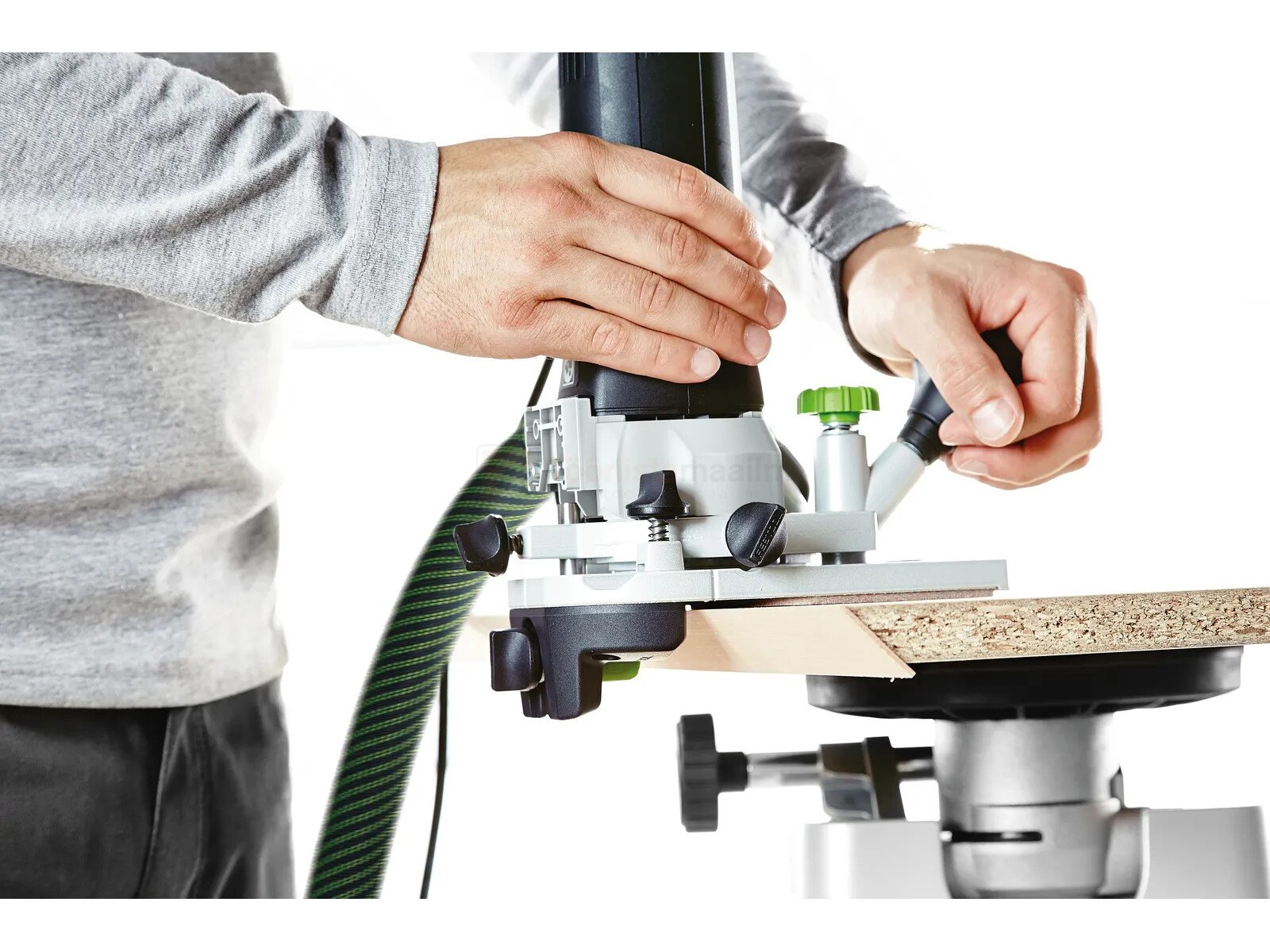 Pildil on näha, kuidas mees kasutab Festool moodul servafreesi MFK 700 KA EQ-Plus, et freesida puidu serva.