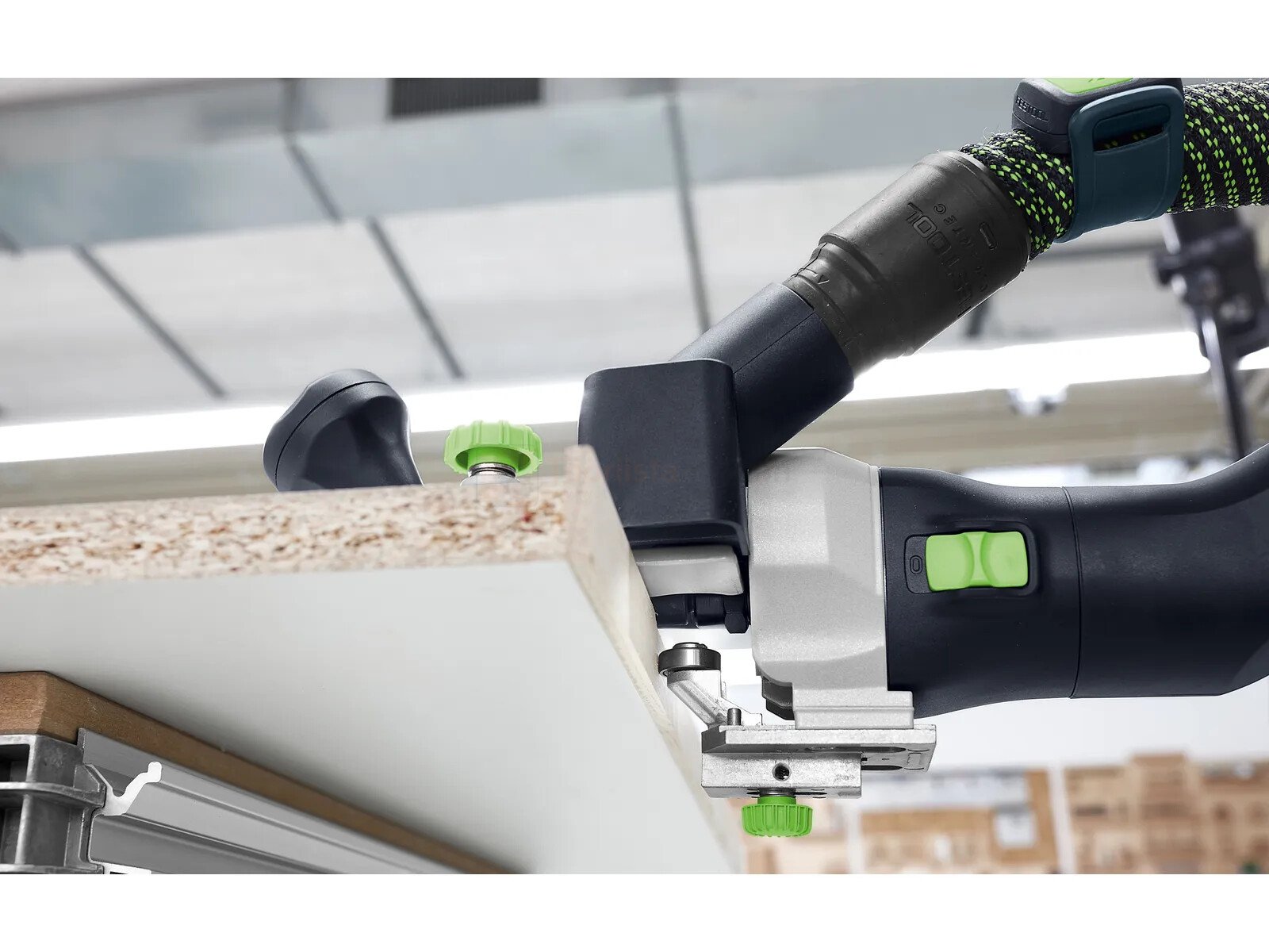Pildil on Festool moodul servafrees MFK 700 EQ-Plus, mis on kinnitatud puidu servale ja mille külge on ühendatud...